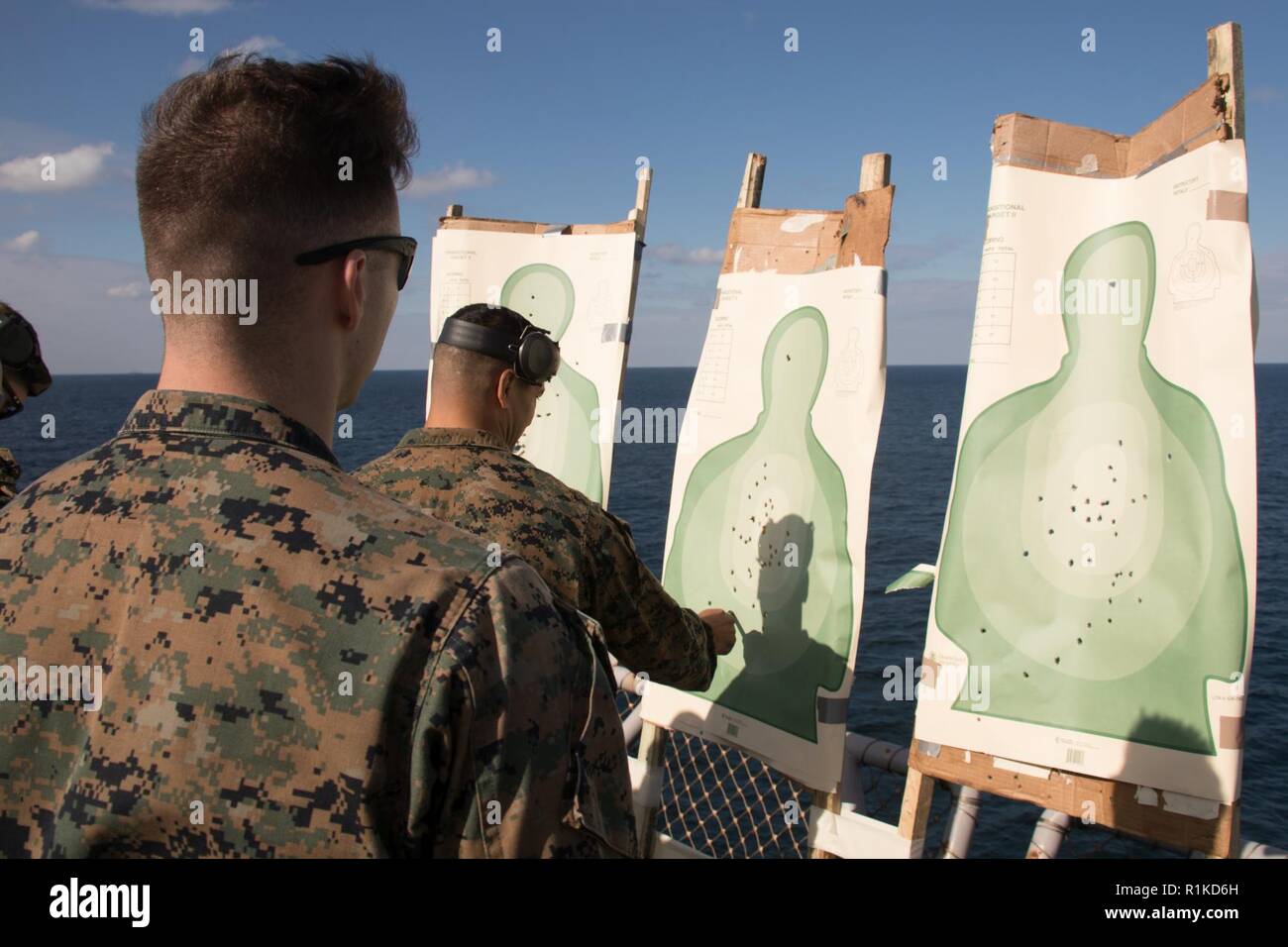 2. Lt. Maxwell Bennett, ein Kommunikation Strategie und Operations Officer mit 31 Marine Expeditionary Unit stellt sein Ziel während der Pistole Qualifikation an Bord der Flight Deck der Amphibisches Schiff USS Wasp (LL 1), unterwegs in der East China Sea, Okt. 15, 2018. Bennett, ein Eingeborener von Stilwell, Kansas, graduiert von William Jewell College im Mai 2016; er im November 2016 in Betrieb genommen. Marines durchlaufen jährlich Gewehr und Pistole Qualifikationen in ihre waffenfertigkeiten und Handhabung vertraut zu bleiben. Die 31. MEU, das Marine Corps' nur kontinuierlich vorwärts - bereitgestellt MEU, bietet eine f Stockfoto