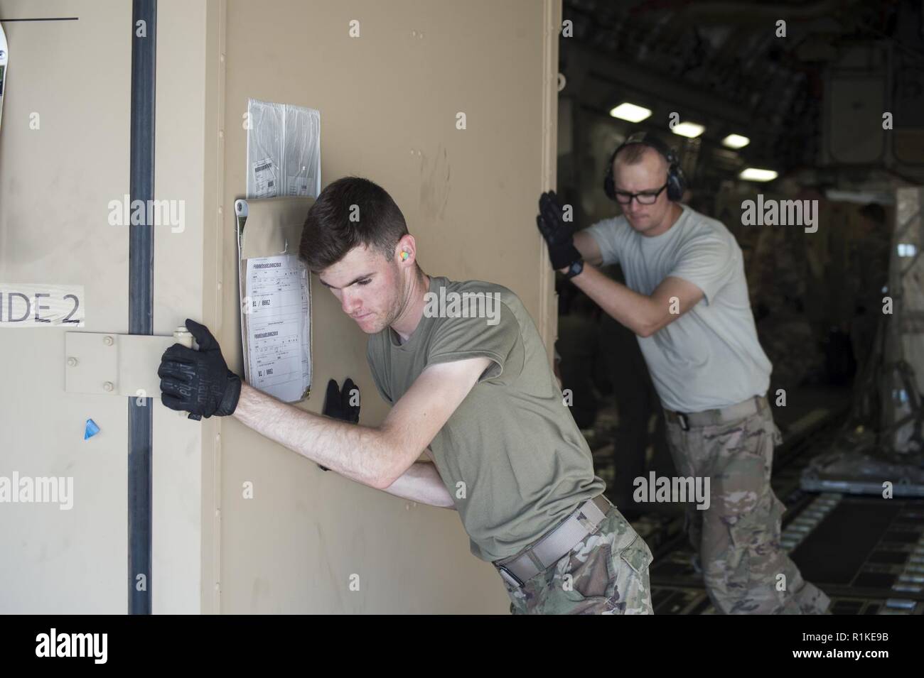 Senior Airman Ryan LaFoe und Tech. Sgt. Vladimir Odnodvorets, 921St Contingency Response Squadron Antenne Torhüter offload einer expeditionary Container aus einem Joint Base Lewis-McChord C-17 Globemaster III, an der Tyndall Air Force Base in Florida, Okt. 14, 2018. Auslieferung des Flugzeuges viel Ausrüstung und Zubehör aus den grundlegenden Expeditionary Flugplatz Einheit Ressourcen aus Holloman AFB, New Mexico benötigt, mit dem Wiederaufbau des Tyndall in der Nachmahd des Hurrikans Michael zu helfen. Ein Bär Paket hat die Fähigkeit, viele Air Force Vermögenswerte reparieren und wiederherstellen, die Mission-ready Geräten für globale Stockfoto