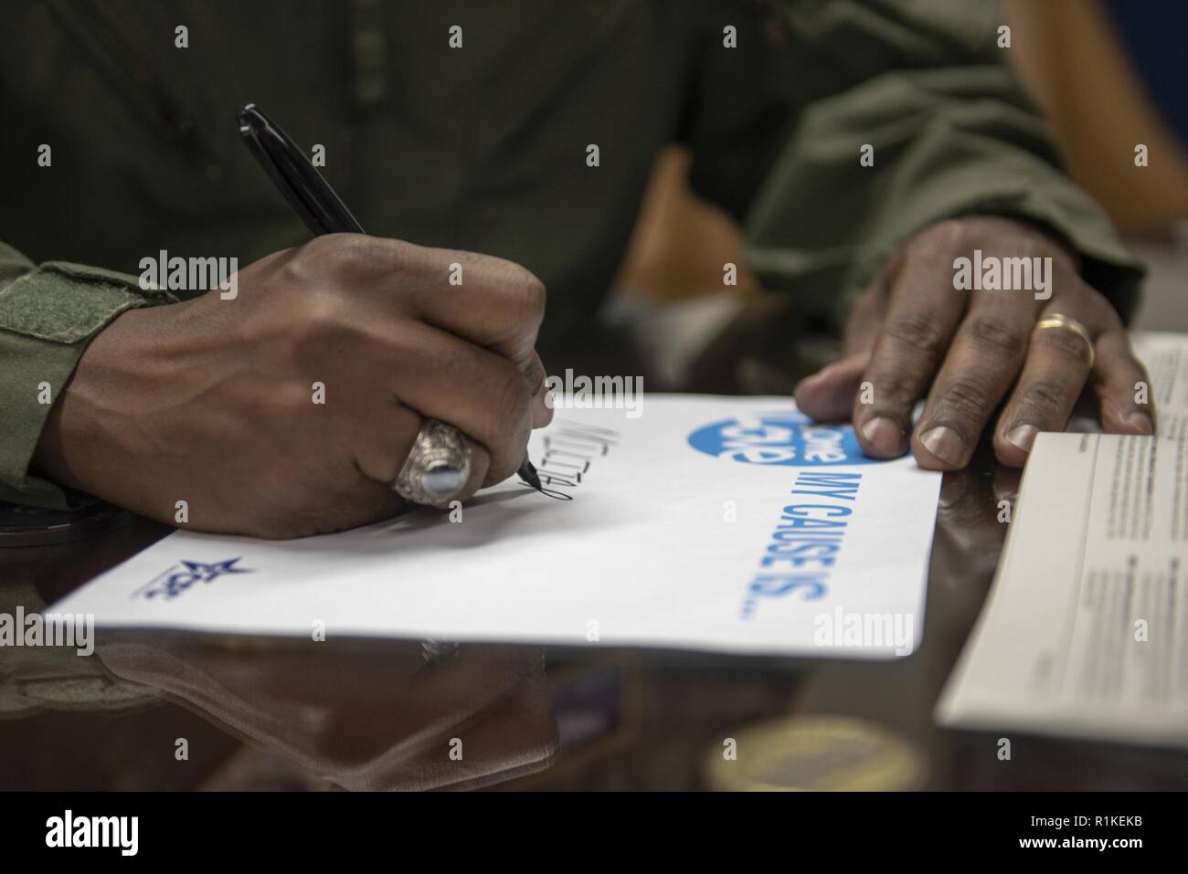 Oberst Otis C. Jones, 374 Airlift Wing Commander, schreibt die Ursache, die er trägt während der Kombinierten Bundestagswahlkampf auf Yokota Air Base, Japan, Okt. 12, 2018. Mit der Kampagne offiziell weg treten bei Yokota am Okt. 15, 2018, alle Mitarbeiter haben die Möglichkeit, das Leben aller durch die wohltätige Spende an, die unterschiedliche Ursachen verbessern. Stockfoto