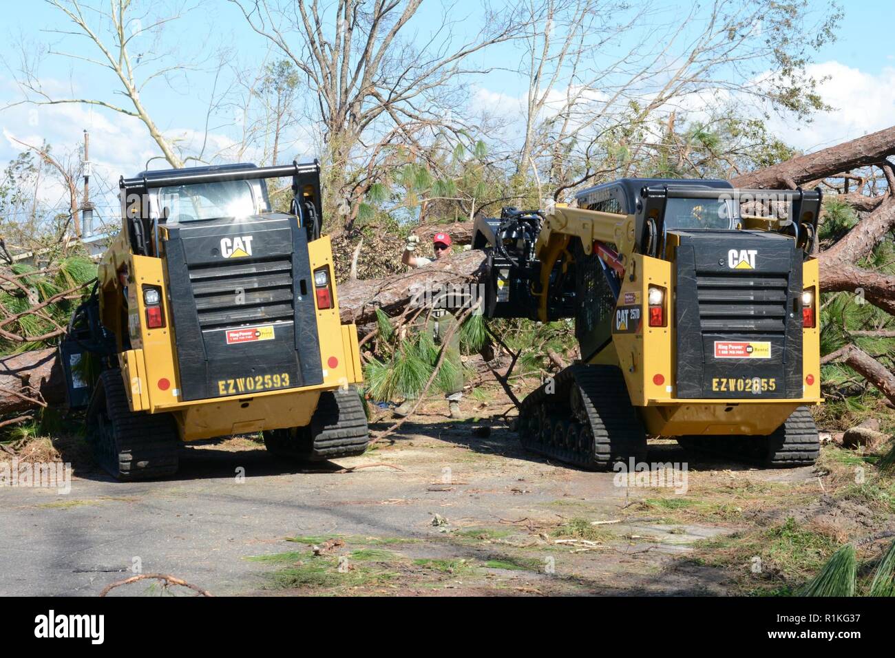 Staff Sgt. Alex Spano, elektrische Facharbeiter und Senior Airman Gonard Caudill, Heavy Equipment operator, sowohl aus der 202. Geben Sie der Camp Blanding, Fla., Tag-Team schweren Baum Ausbau in einer Nachbarschaft innerhalb der 10 Mile Road Bereich von Panama City 16. Okt., 2018, mit einem von Master Sgt. Christopher Fischer, auch Heavy Equipment Operator aus der 202 nd. Der 202 wurde für ihr Know-how in der effizienten Route clearing genannt nach dem Hurrikan Michael durch kamen. Stockfoto