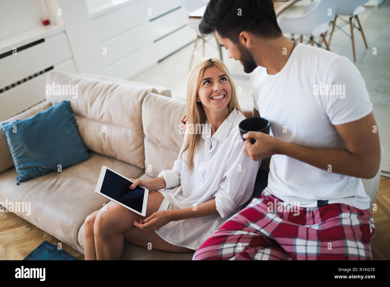 Glückliches Paar in der Liebe mit Tablet im Schlafanzug Stockfoto