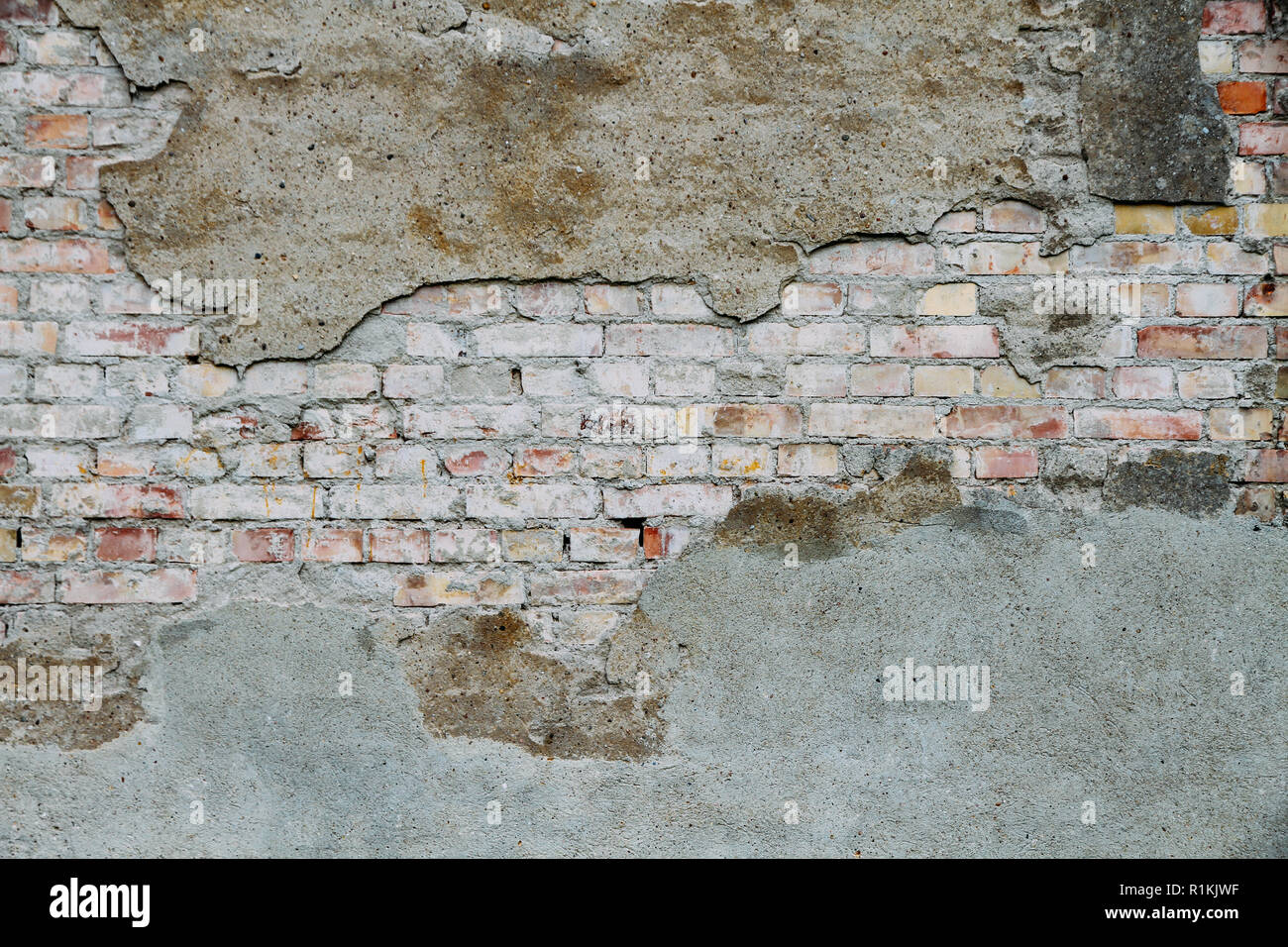 Alte und verwitterte grungy gebrochene Mauer aus verlassenen Haus teilweise überdacht mit alten Zement mit Peeling Lackierung als Textur Hintergrund. Stockfoto