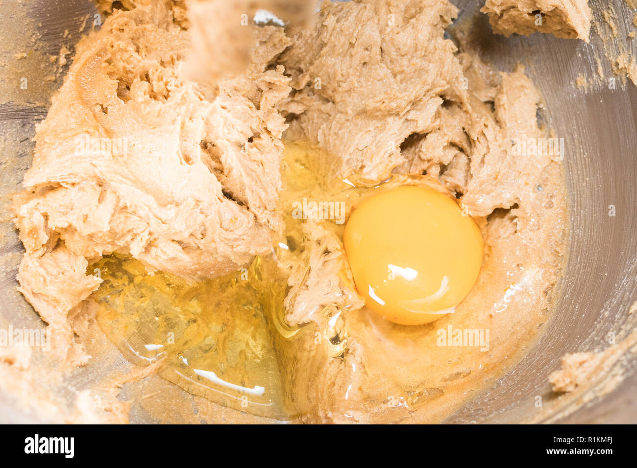 Kuchen backen - Hinzufügen Ei brauner Zucker und Butter zu Sahne - Kuchen Mischung Stockfoto