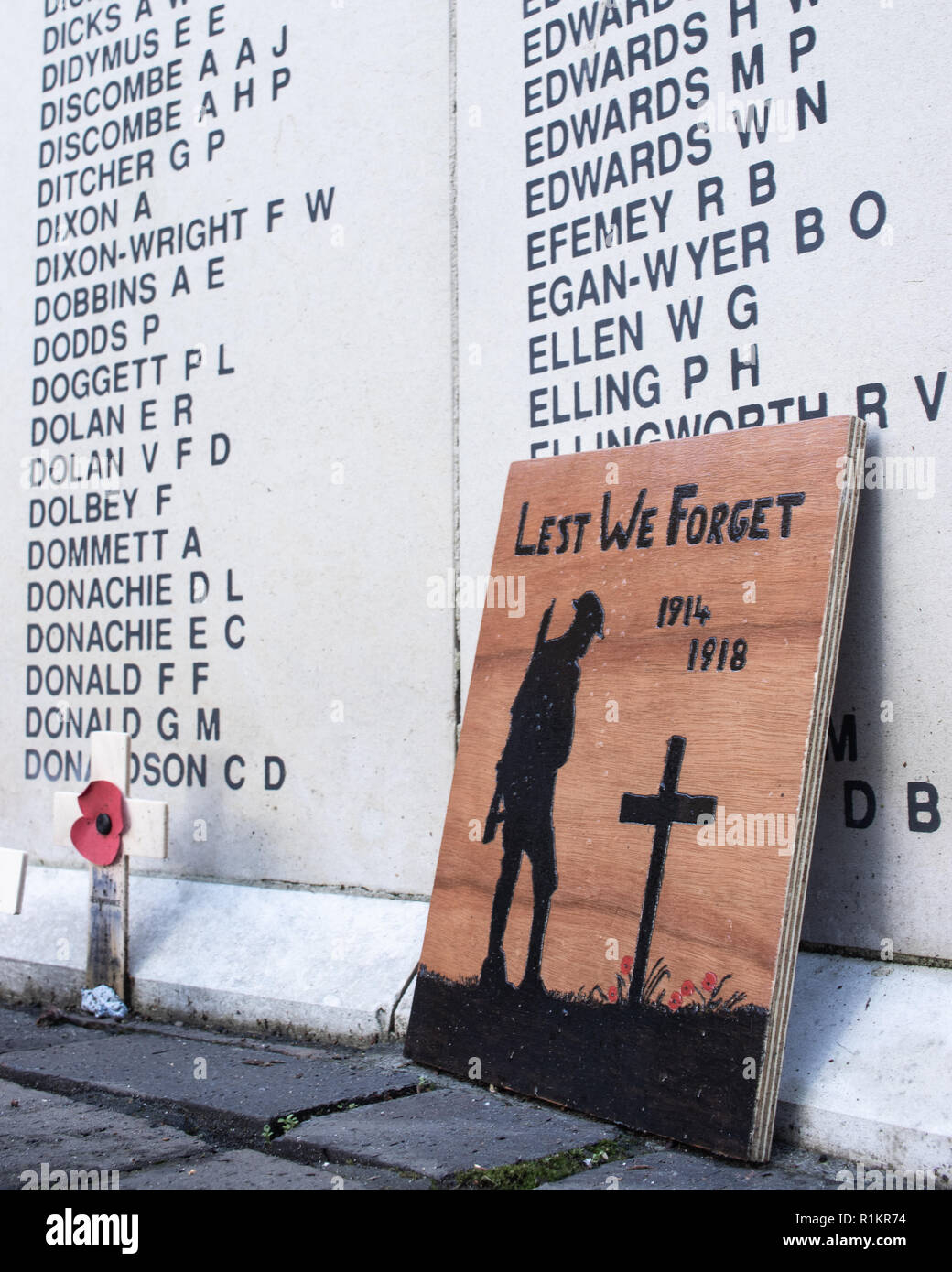 Ein Tag der Erinnerung Poppy und Kreuz vor der Namen des writted ein Kriegerdenkmal Stockfoto