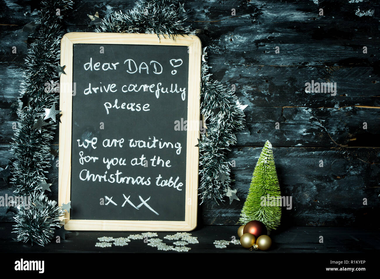Auf einem Weihnachten Hintergrund eine Tafel mit einer Meldung vom Kind zum Vater: Fahren Sie vorsichtig, wir warten auf Sie Stockfoto