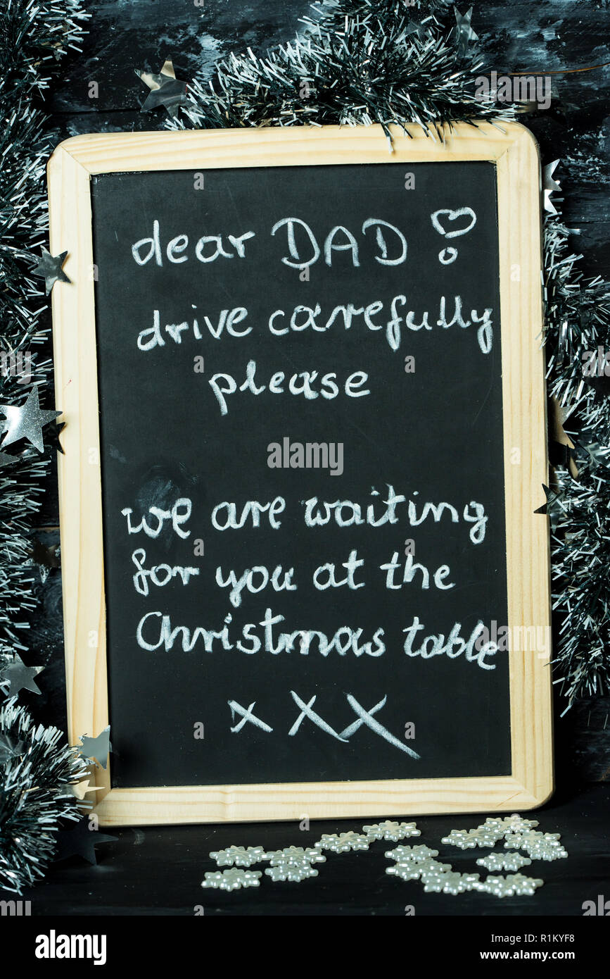 Auf einem Weihnachten Hintergrund eine Tafel mit einer Meldung vom Kind zum Vater: Fahren Sie vorsichtig, wir warten auf Sie Stockfoto