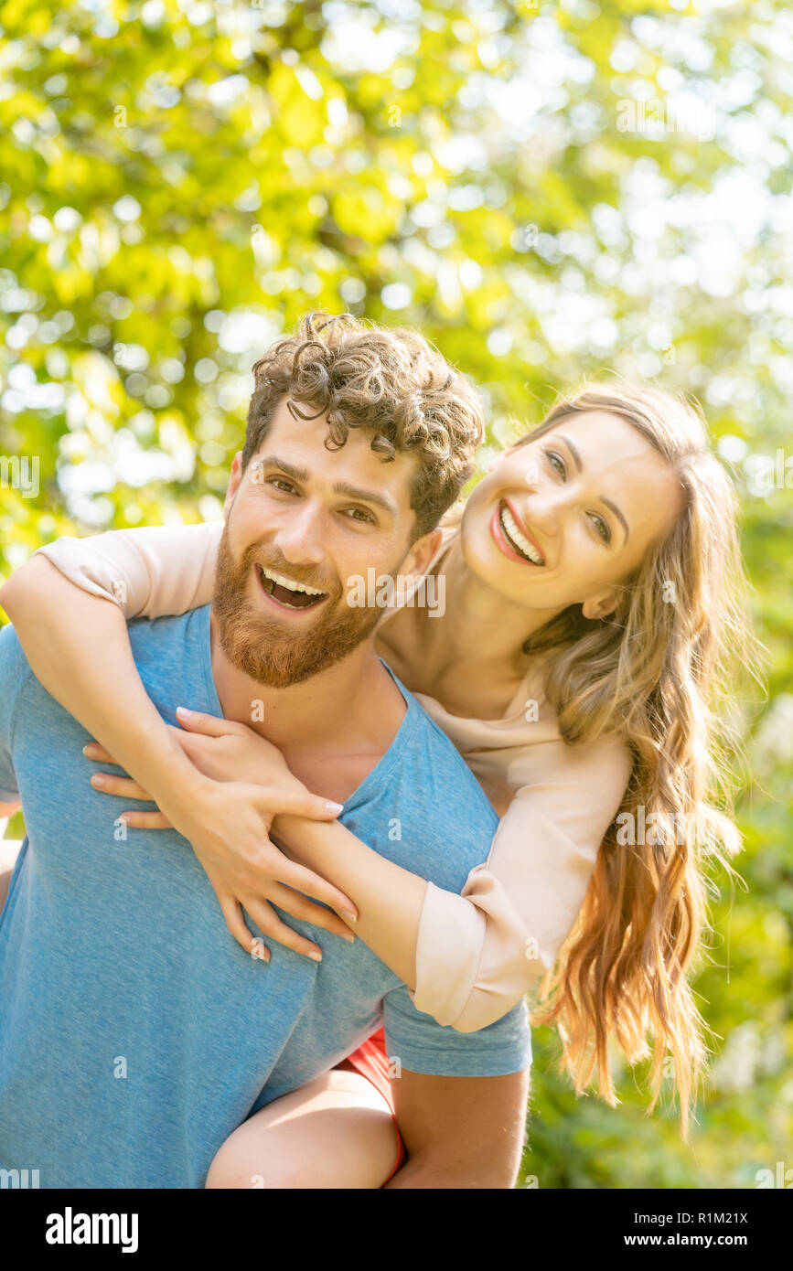 Mann ist mit seiner Frau auf seinem Rücken einen starken und zuverlässigen Partner Stockfoto