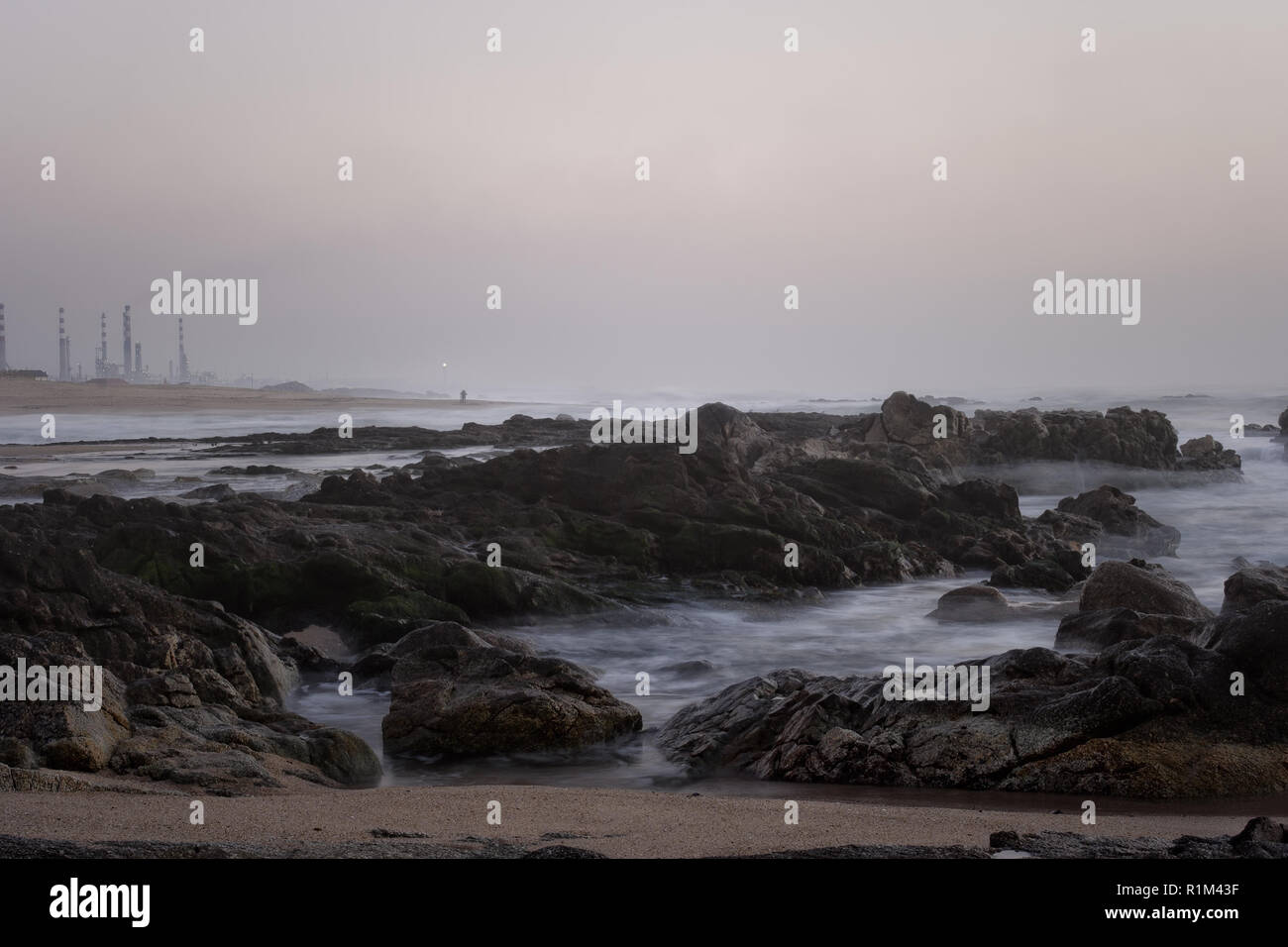 Felsigen Strand aus dem Norden Portugals bei Nebel der Dämmerung. Lange Belichtung. Stockfoto