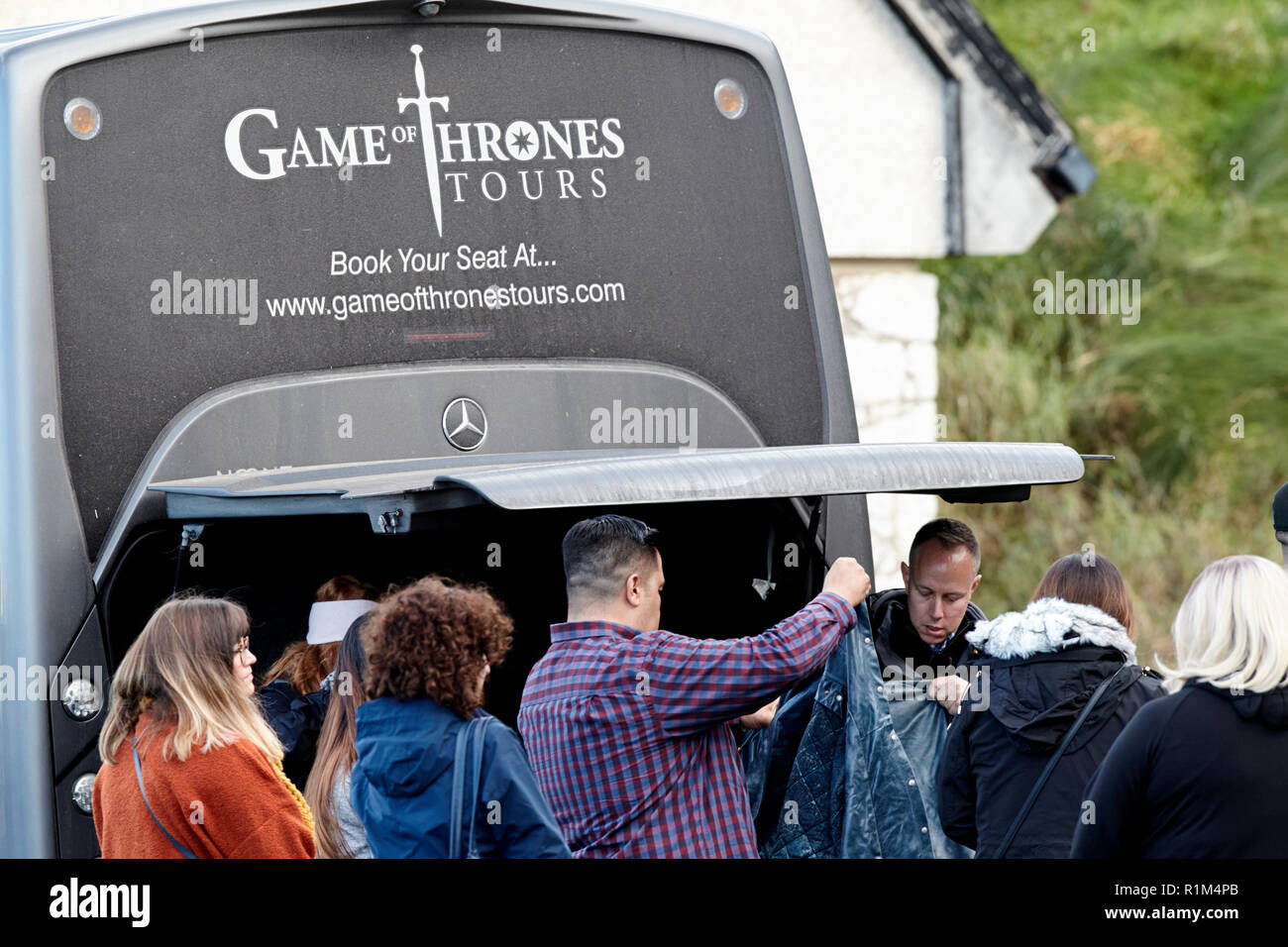 Touristen auf Kostüme auf ein Spiel der Throne geführte Bustour in Ballintoy auf Nordirelands North Coast Stockfoto