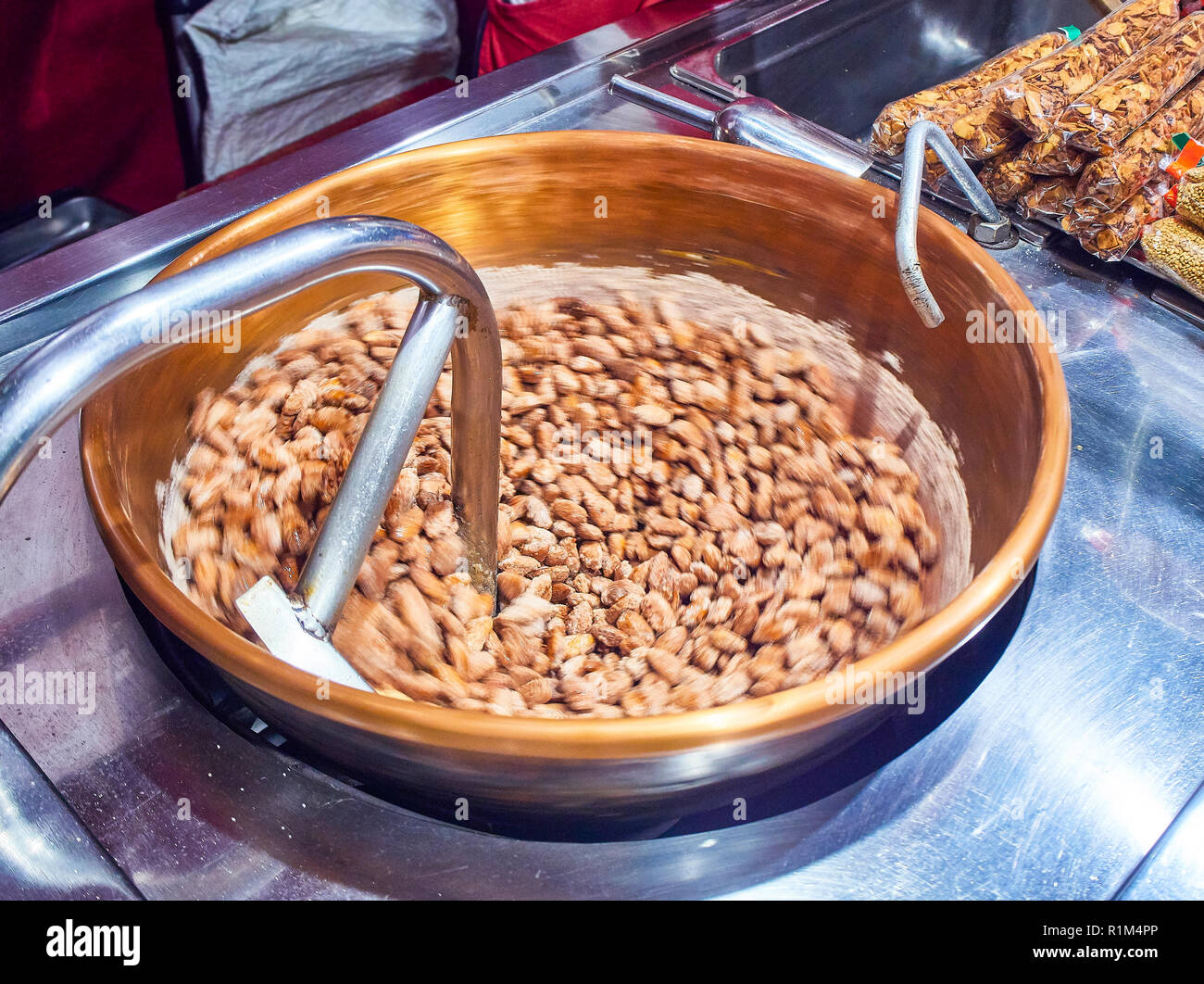 Kochen kandierte Mandeln, caramelizing entfernt auf einem großen Metall gerben Topf an einer Europäischen Messe. Stockfoto