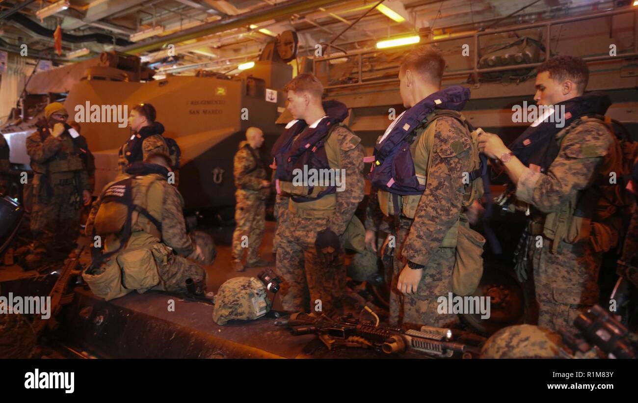 Sardinien, Italien - (Okt. 2010) 12, 2018) - US-Marines mit dem Force Reconnaissance Det. Der Bataillon Landung Team 3/1, 13 Marine Expeditionary Unit (MEU), und die Mitglieder des ersten Regiments San Marco Brigade italienische Landung Kraft auf das Zahnrad und Ausrüstung vorbereiten, bevor ein Ship-to-shore Amphibisches während der Übung Mare Aperto, Okt. 12, 2018. Mare Aperto ist für den Kombinierten verbessern Bekämpfung Capability, erhöhen die Kapazität, und die Beziehungen zwischen Übung die Teilnehmer stärken. Stockfoto