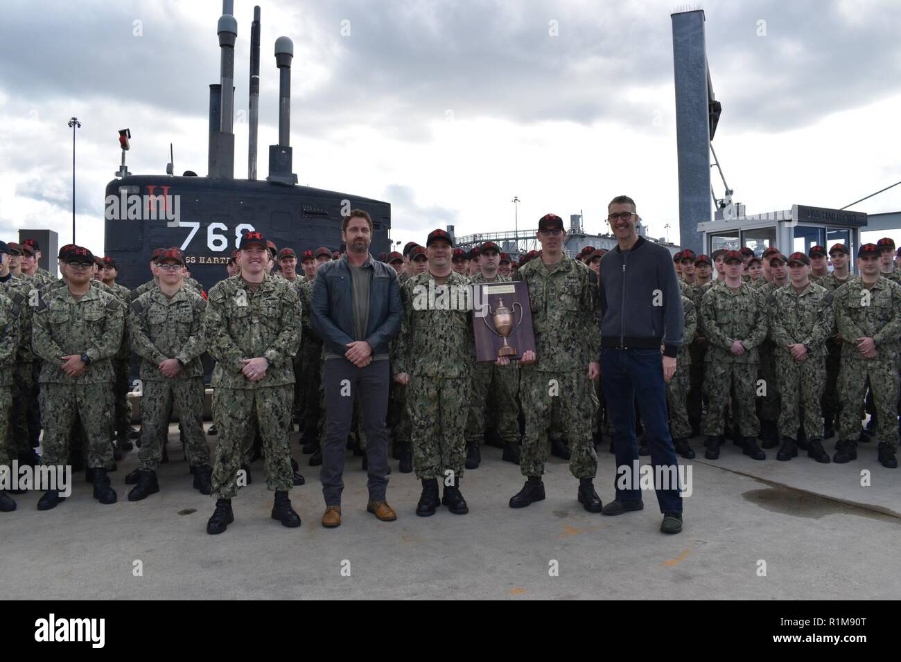 GROTON, Anschl. (23. 20, 2018) - Gerard Butler und Donovan Marsh, Stern und Direktor des upcoming Film "Hunter Killer, "pose mit der Crew der USS Hartford (SSN768) während einer Feierstunde für die 2017 Battenberg Cup Award. Die battenberg Cup wird jährlich an die besten Rund-um-Schiff oder U-Boot im Atlantik Flotte auf der Anhäufung von Erfolg der Mannschaft vorgestellt. Butler und Marsh besucht Naval Submarine Base New London in einem speziellen voraus Überprüfung ihrer bevorstehenden Film "Hunter Killer" zu beteiligen. Stockfoto