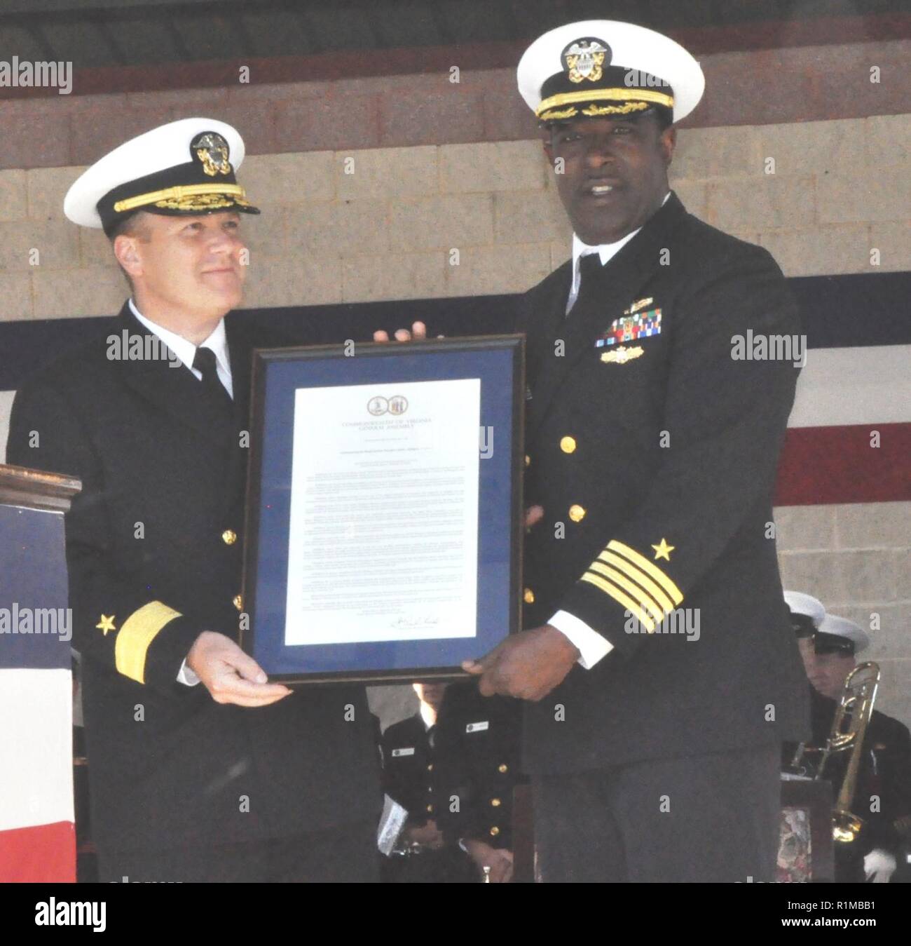 DAHLGREN, Va (Okt. 2010) 19, 2018) - Adm. Tom Anderson, Naval Surface Warfare Center (NSWC) Commander, und Kapitän Godfrey 'Gus' Weekes, NSWC Dahlgren Division kommandierender Offizier halten Sie die Virginia Resolution der Generalversammlung der Verkündigung 16. Okt. als dahlgren Tag während das Grand Finale Feier der NSWC Dahlgren Division Centennial. Virginia State Sen. Richard Stuart und Virginia delegieren Margaret Ransone lesen und präsentiert die Lösung auf der Veranstaltung. Stockfoto