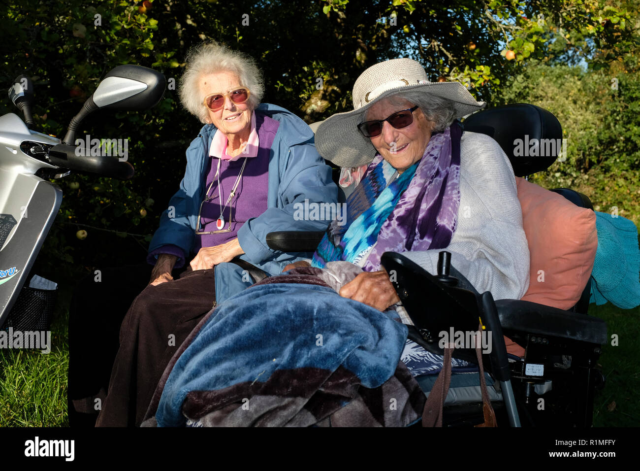 Alte Damen mit ihren angetriebene Rollstühle Genießen der Sonne Stockfoto