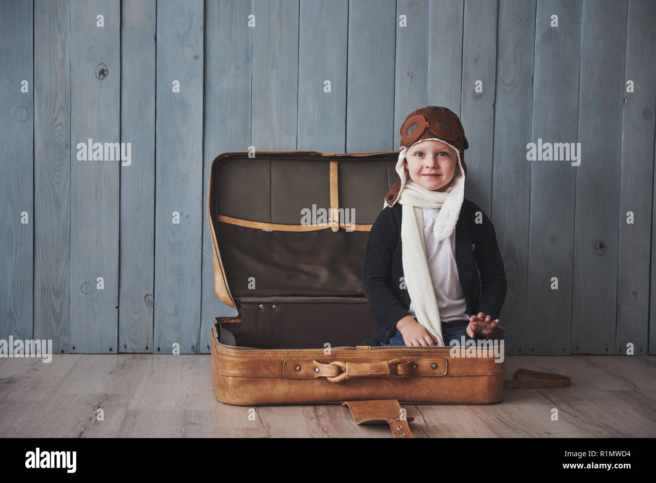 Glückliches Kind in Pilot hat das Spiel mit dem alten Koffer. Kindheit. Fantasie, Vorstellungsvermögen. Urlaub Stockfoto