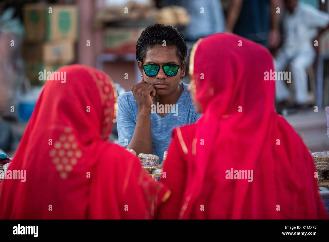 Street Hawker, einem trendigen Verkäufer zu zwei Rajasthani Frauen in Jodhpur, Indien Stockfoto