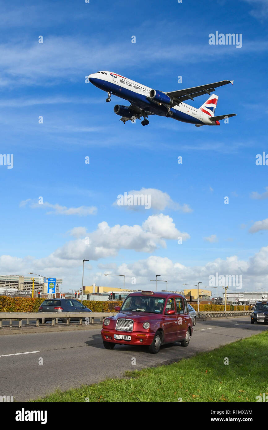 LONDON, ENGLAND - NOVEMBER 2018: British Airways Jet in Land am Flughafen London Heathrow kommend über den Verkehr auf der A 30 Schnellstraße. Stockfoto