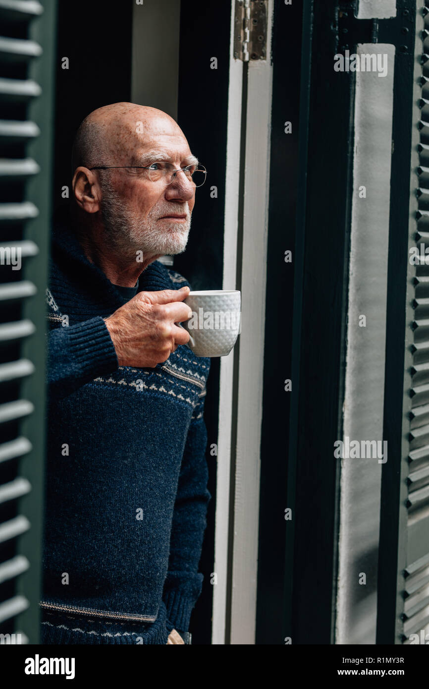 Ältere Person, die in der Nähe der Tür, Kaffee zu trinken. Alte person Kaffee trinken, während aus der Tür. Stockfoto