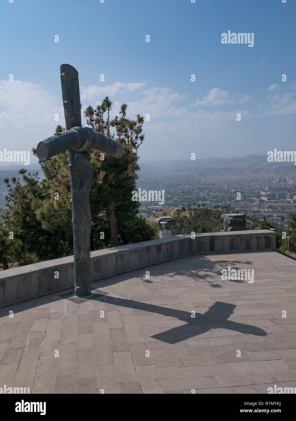 Kreuz neben der Basis der Chronik von Georgia mit Tiflis im Hintergrund. Stockfoto