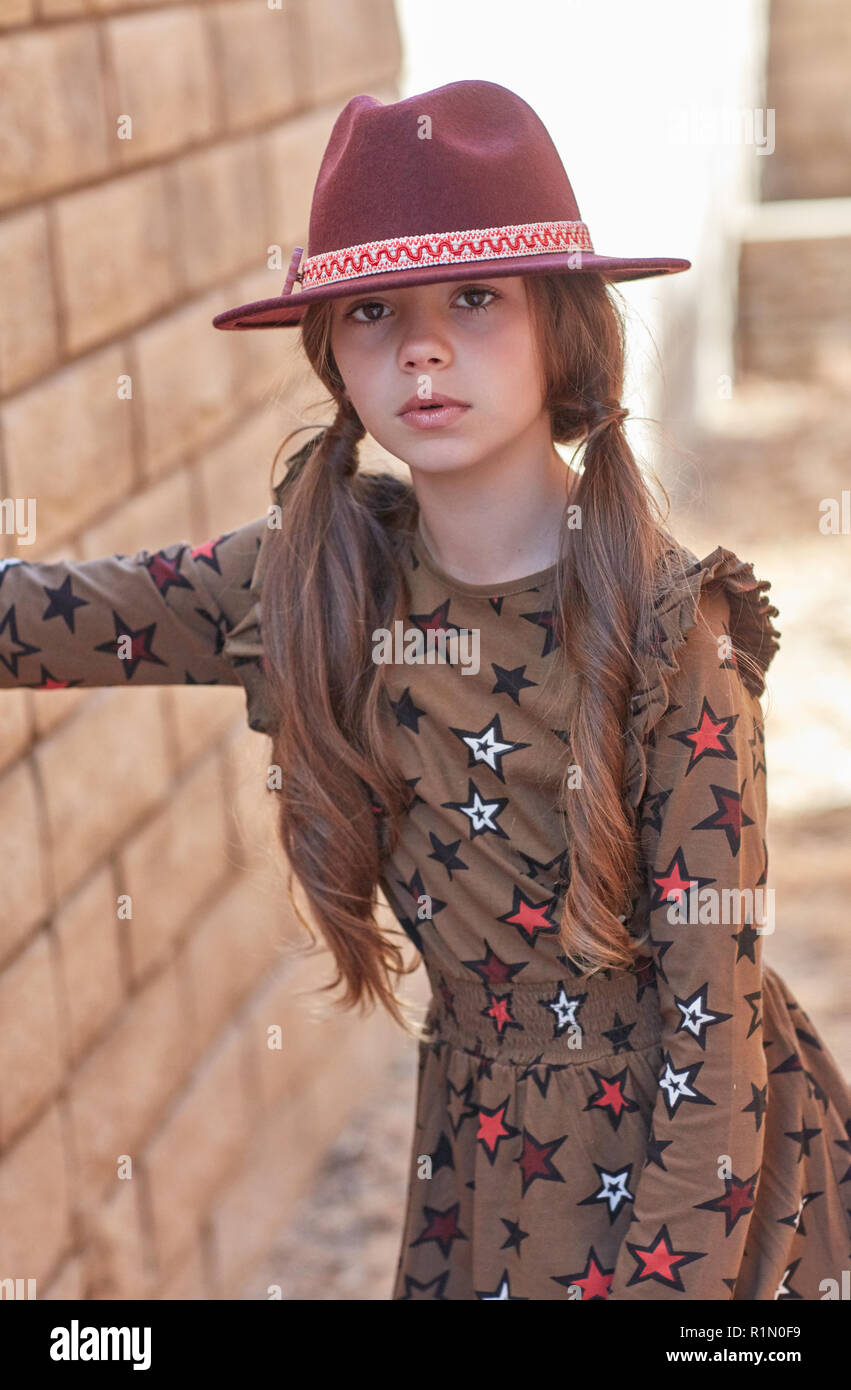 Junge Mädchen mit einem Burgund hat und ein braunes Kleid mit Stars bei Kamera suchen Stockfoto