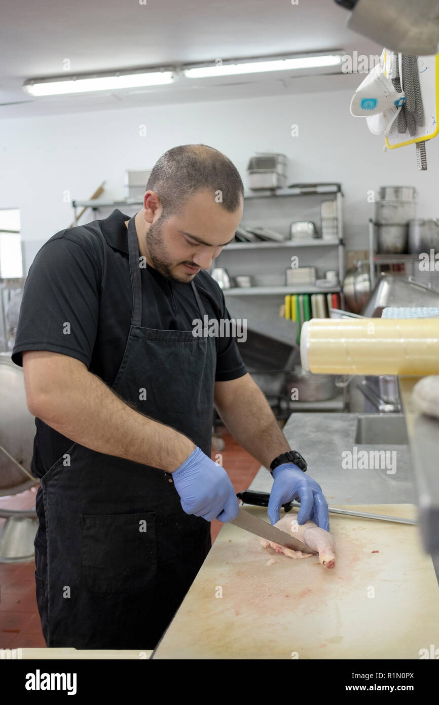 Ein israelischer Bewohner eines Kibbuz Kfar HaRuv auf den Golanhöhen arbeitet in der lKitchen Vorbereitung Huhn für das Abendessen. Stockfoto