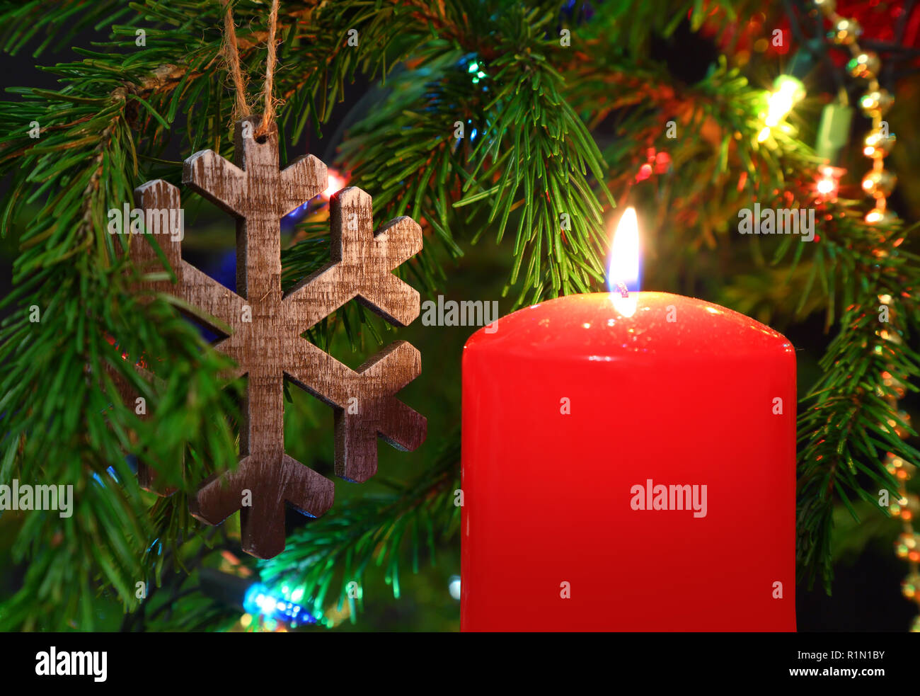 Weihnachten - Kerze und hölzernen Schneeflocke auf Tanne Stockfoto