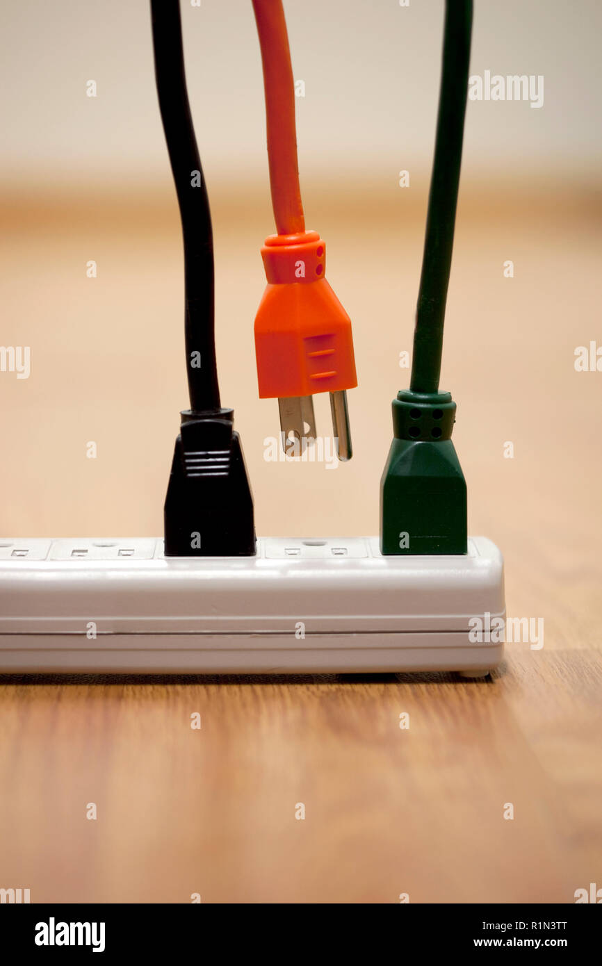 Elektrische Kabel und eine Steckdosenleiste mit Überspannungsschutz Steckdosenleiste mit einem Kabel ausgesteckt Stockfoto