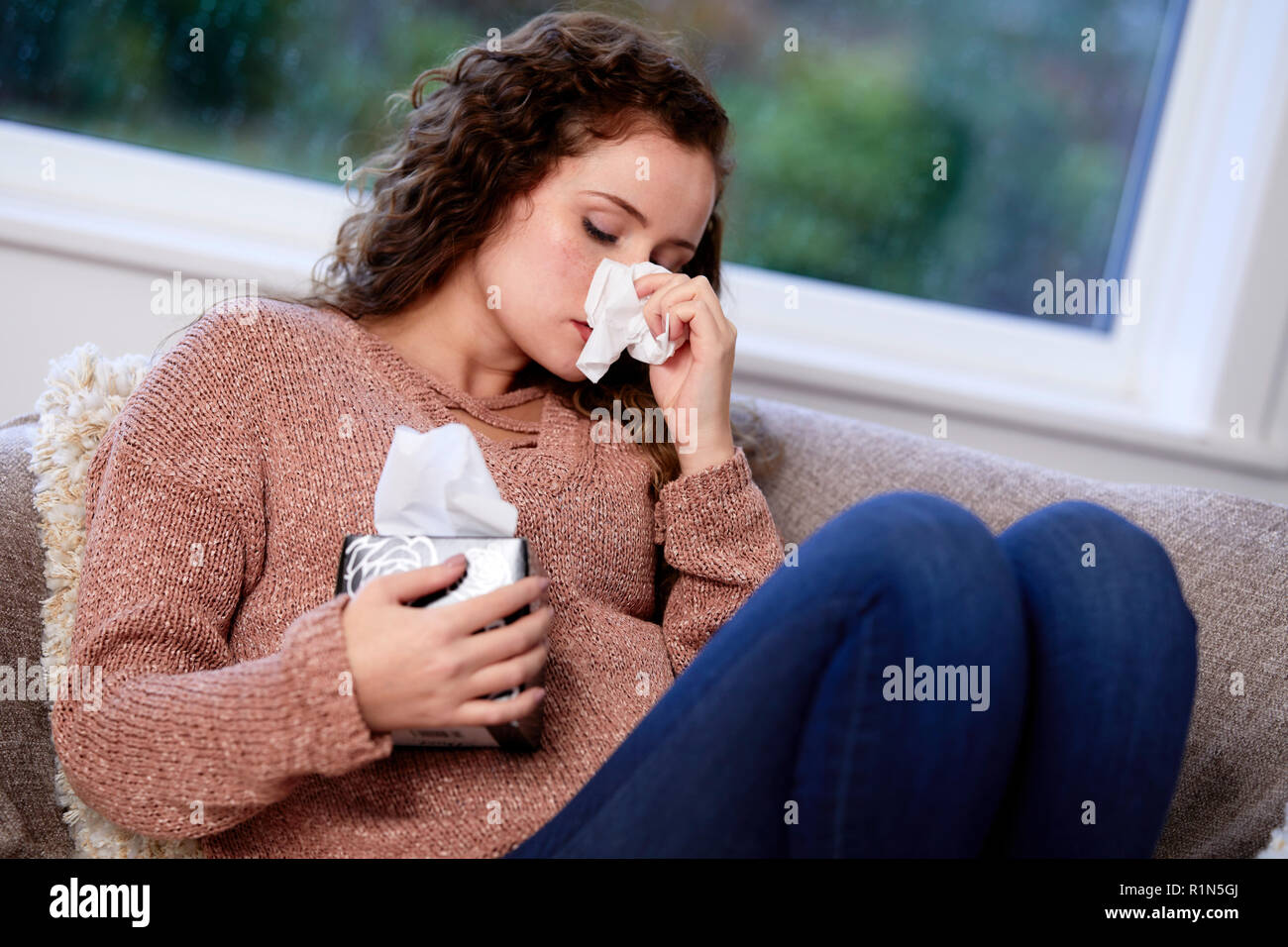 Frau mit Gewebe ihre Nase weht Stockfoto