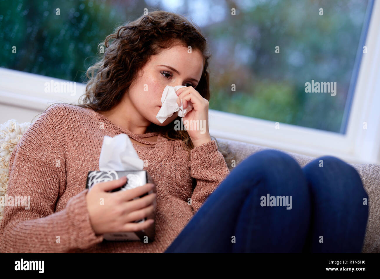 Frau mit Gewebe ihre Nase weht Stockfoto