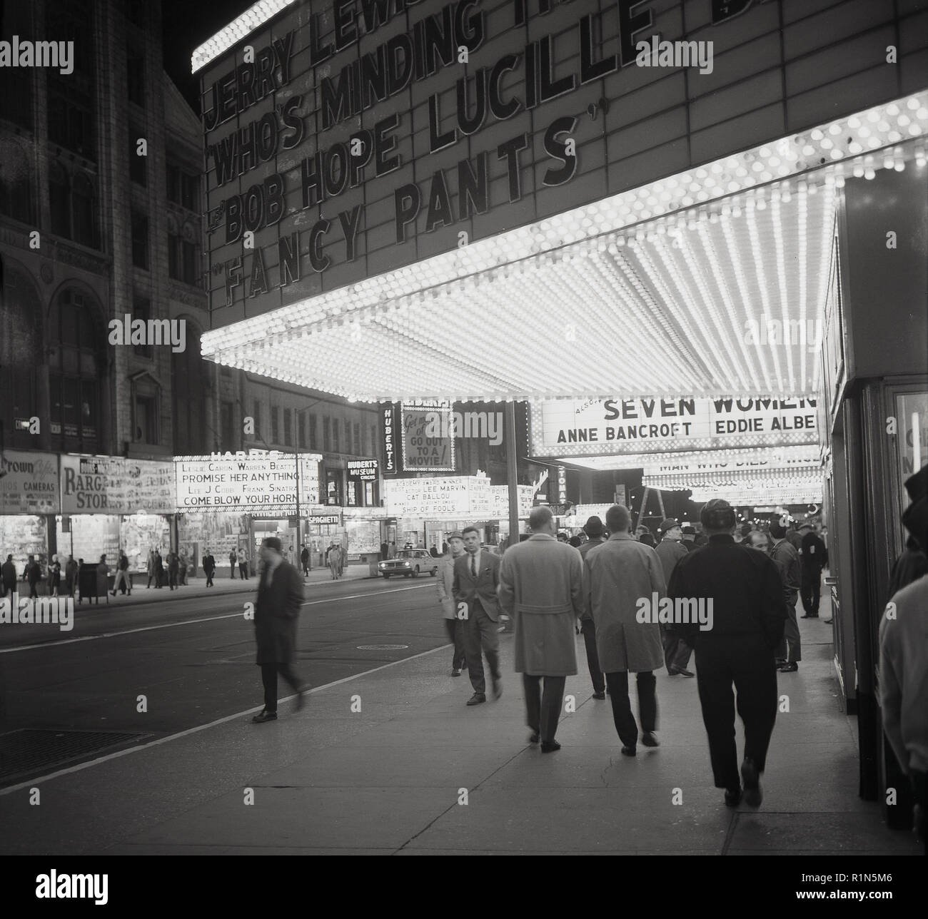 1963, am Abend am Times Square, Midtown Mahattan, Theater District von New York und die Neonlichter der Kinos und Theater auf der Straße. In dieser Zeit, die Jerry Lee Lewis Comedy Film, "Wer um den Speicher" und der Film "Fancy Pants", in den Hauptrollen, Bob Hope und Luciille Ball. Stockfoto