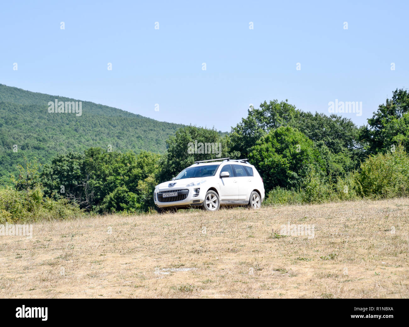 Wälder neben dem Dorf Shapsugskaya, Russland - Juli 30, 2016: Weiße crossover Peugeot 4007 auf dem Hügel. Stockfoto