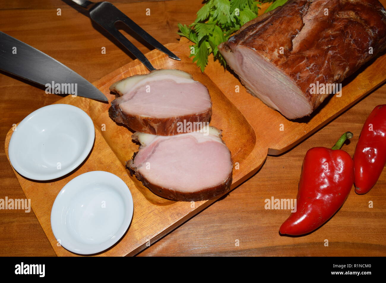 Kassler auf Holz rustikale Platte. Es ist oft mit Sauerkraut und Kartoffelpüree serviert. Vollständig ausgehärtet und geräuchertem Schweinefilet Koteletts auf einer hölzernen Fach gekocht Stockfoto