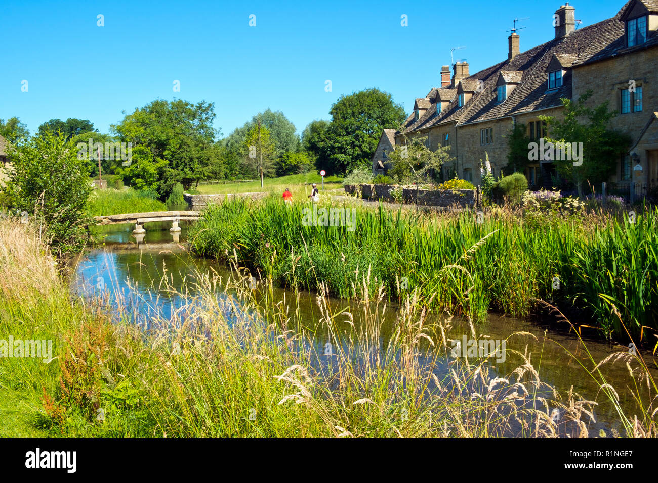 Lower Slaughter, Gloucestershire, Großbritannien - Juli 2016 19: Sommer Sonnenschein bringt Besucher zum malerischen Cotswold Dorf Lower Slaughter, Gloucestershire, UK. Das Dorf erstreckt sich über den kleinen Fluss Auge und mehrere kleine Stege und ein Ford die beiden Seiten der Community beitreten. Stockfoto