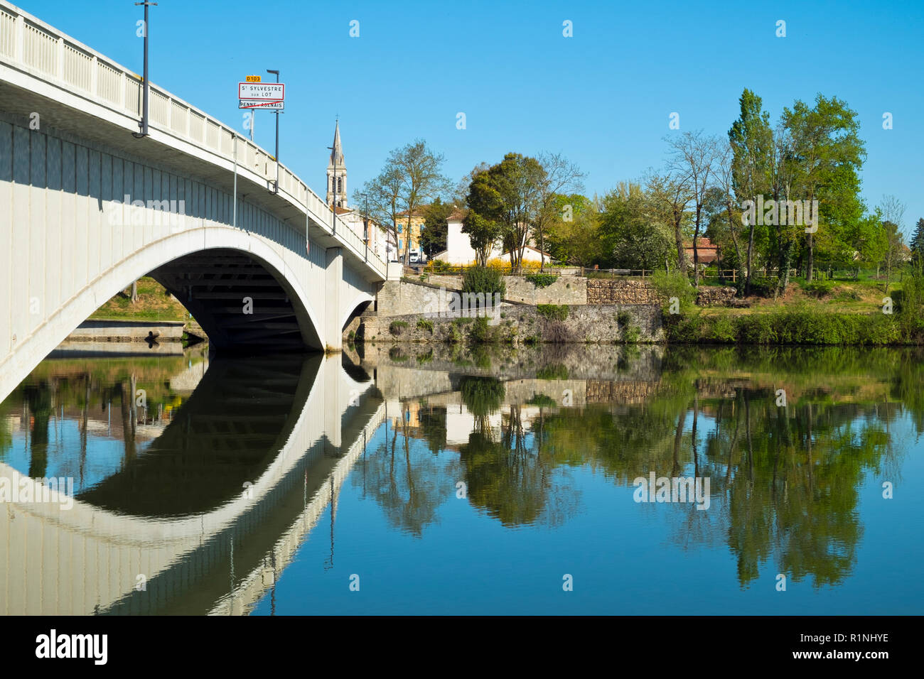 Blick über den ruhigen Fluss Lot an St-Sylvestre-sur-Lot, Lot-et-Garonne, Frankreich von Port de Penne (Penne d'Agenaise) in herrlichen Frühlingssonne. Stockfoto