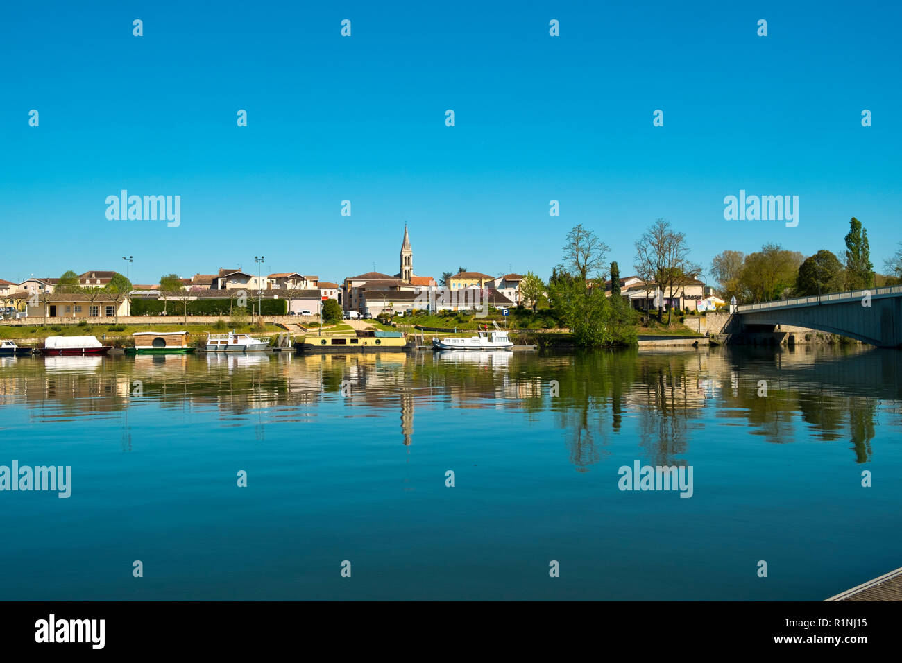 Blick über den ruhigen Fluss Lot an St-Sylvestre-sur-Lot, Lot-et-Garonne, Frankreich von Port de Penne (Penne d'Agenaise) in herrlichen Frühlingssonne. Stockfoto