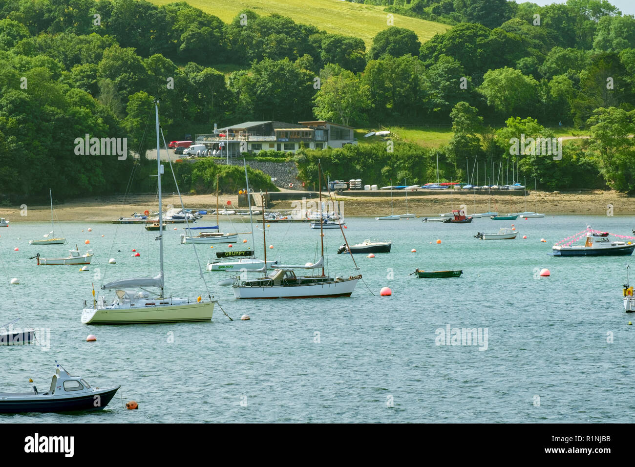 Helford Passage, Großbritannien - 8. Juni 2017: Der Blick über die malerischen Helford River, wo viele kleine Boote in der Nähe des ländlichen Helford Dorf in Cornwall, UK vor Anker liegen. Die Helford River ist eine Ria (überfluteten Fluss Tal) sowie ein Reiseziel in der Cornwall bekannt Stockfoto