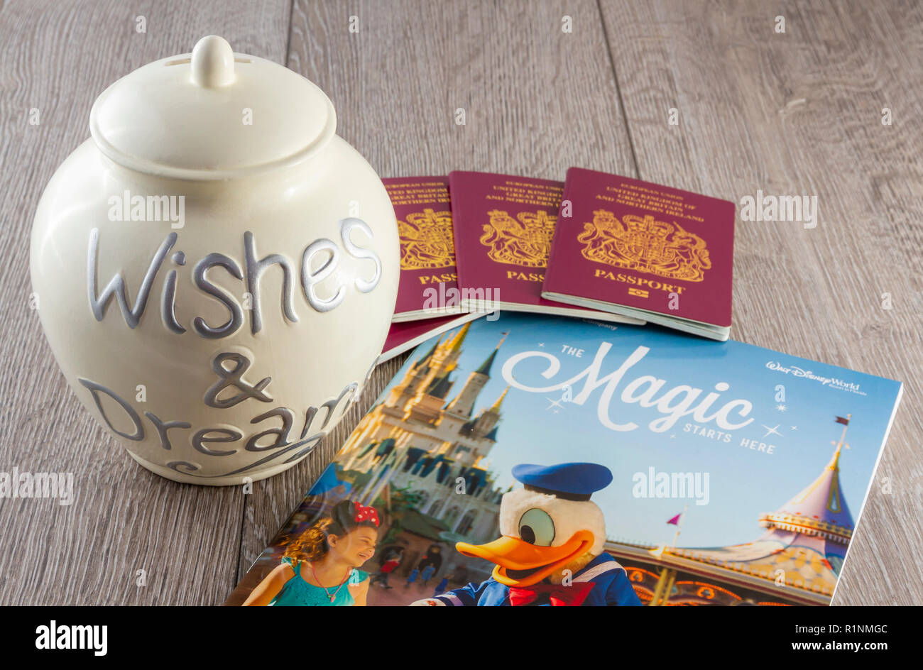 Britische Pässe und eine Einsparung Glas mit einem Disney World Travel Broschüre Stockfoto