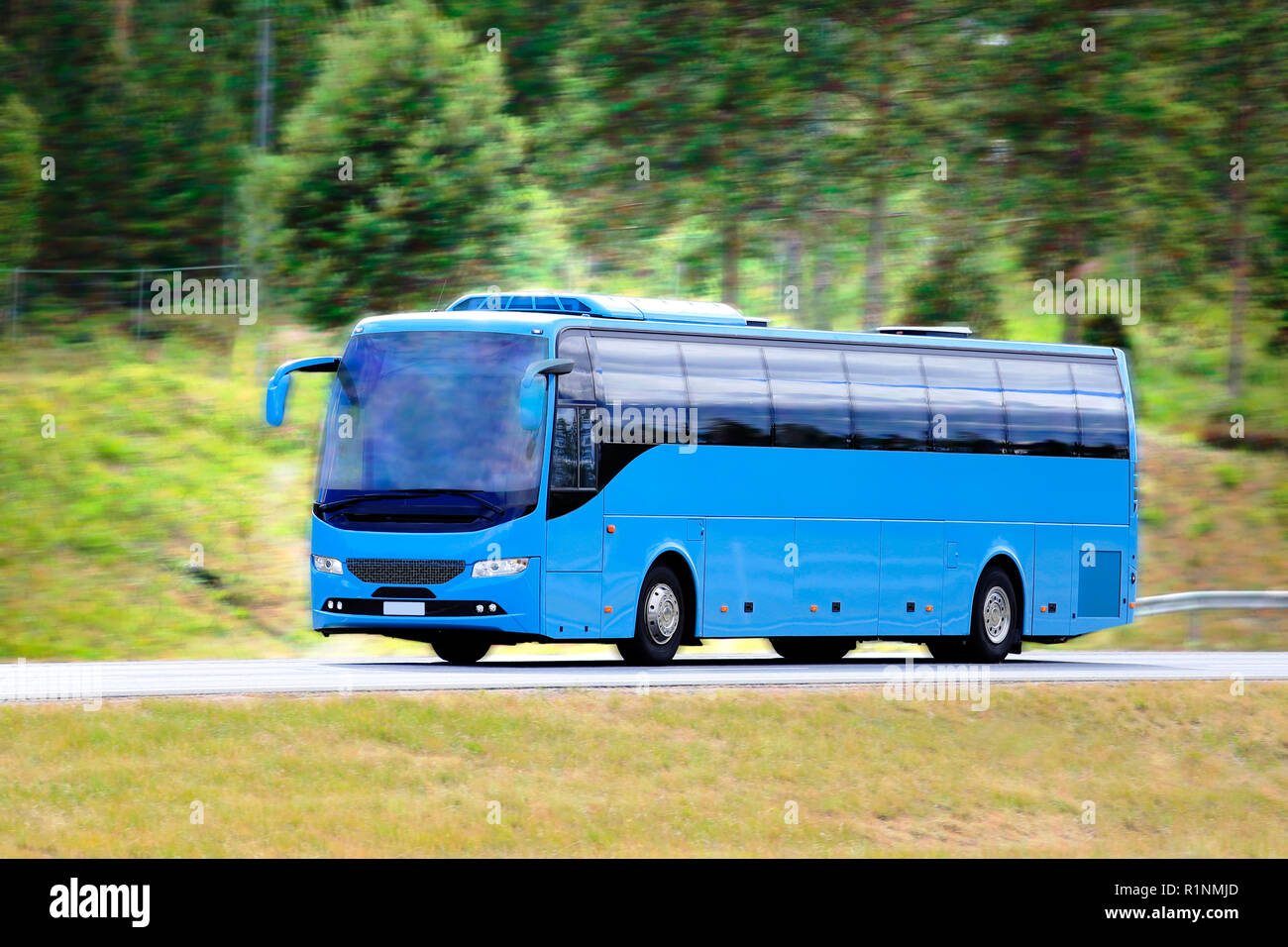 Modernes Blue Bus Bus an Geschwindigkeit auf der Autobahn an einem sonnigen Tag im Sommer. Hintergrund mit Bokeh Effekt und Bewegungsunschärfe. Stockfoto