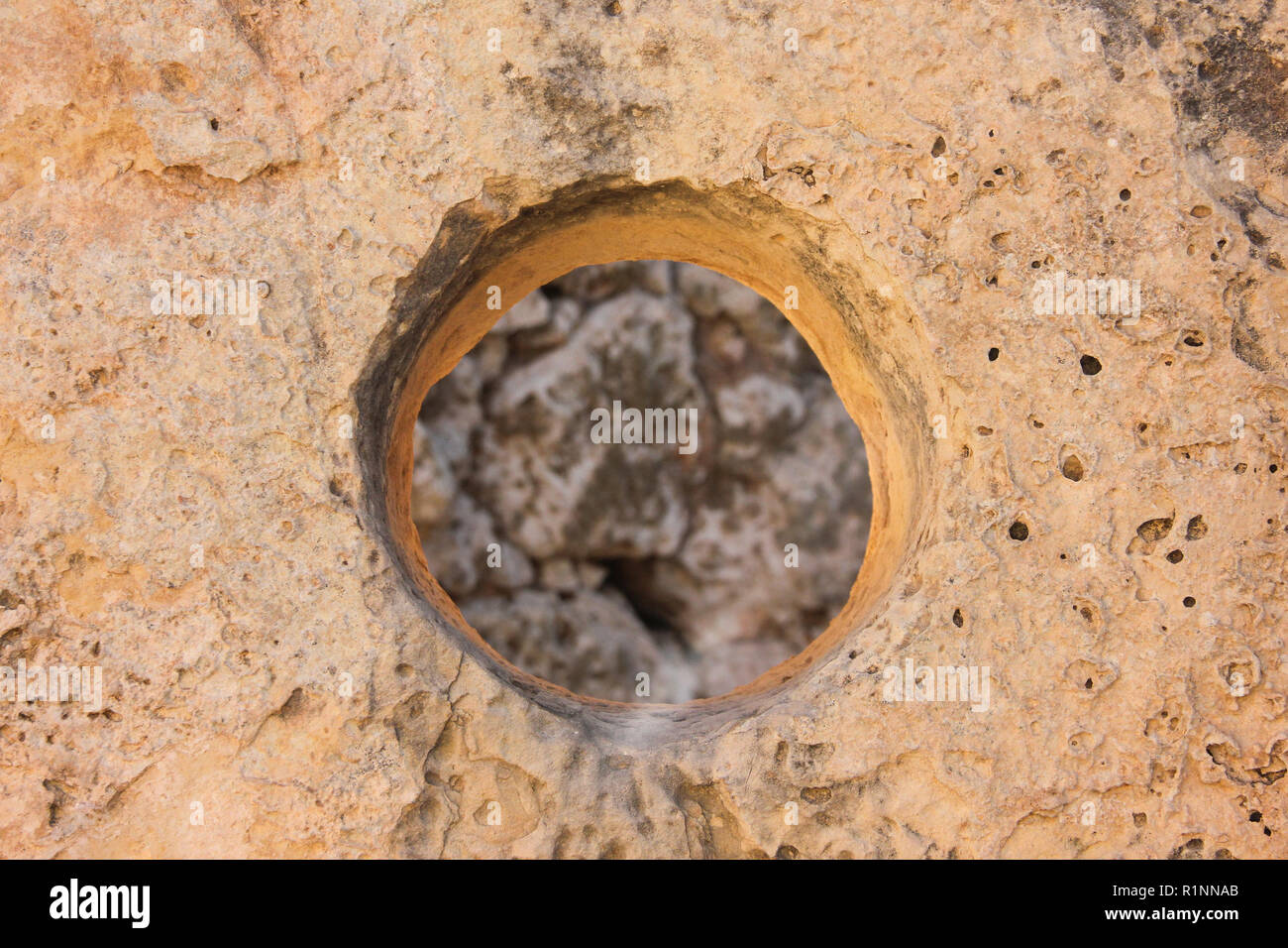 Runde Öffnung im verfallenen Steinmauer Hintergrund Stockfoto