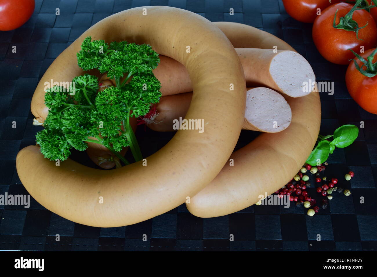 Lyoner ist eine Wurst Feinkost auf einem schwarzen Tischset. Lyoner ist ein wurst-delikatessen in einem schwarzen Tischset. Stockfoto