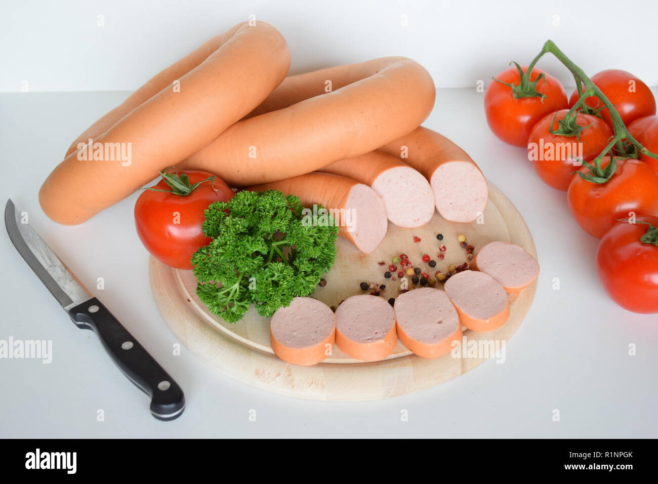 Lyoner ist eine Wurst Feinkost auf einer hölzernen runde Platte. Lyoner ist eine Wurstspezialität mit einer runden Holzplatte. Stockfoto