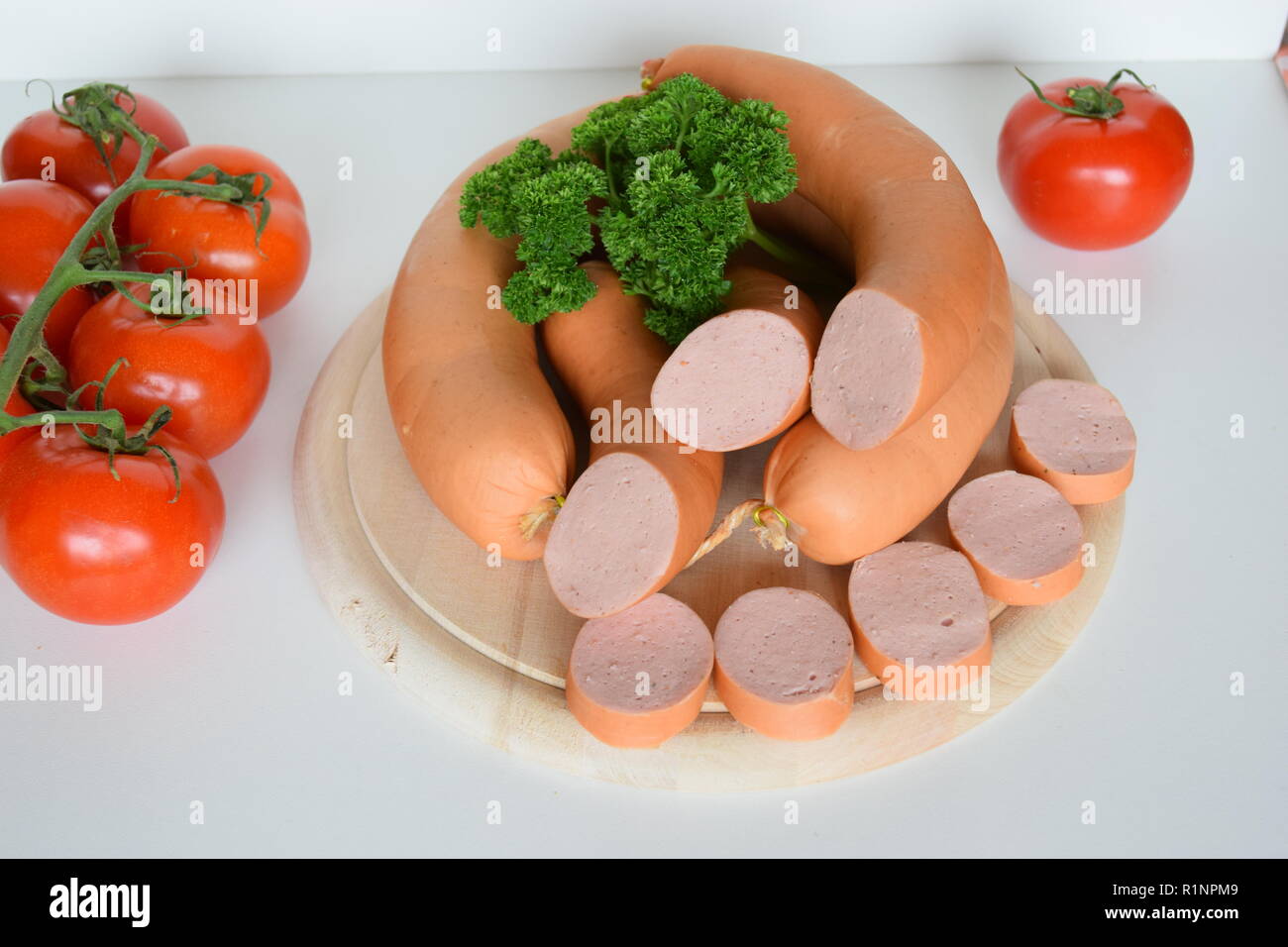 Lyoner ist eine Wurst Feinkost auf einer hölzernen runde Platte. Lyoner ist eine Wurstspezialität mit einer runden Holzplatte. Stockfoto