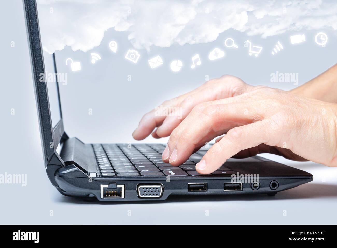 Cloud Computing Konzept Hände schreiben auf Tastatur mit Common Internet medien Symbole unter Wolken aus dem Bildschirm des Laptops. Stockfoto