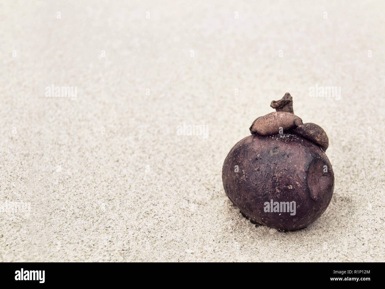 Die verblichenen Frucht einer mangostin liegt am Sandstrand Stockfoto