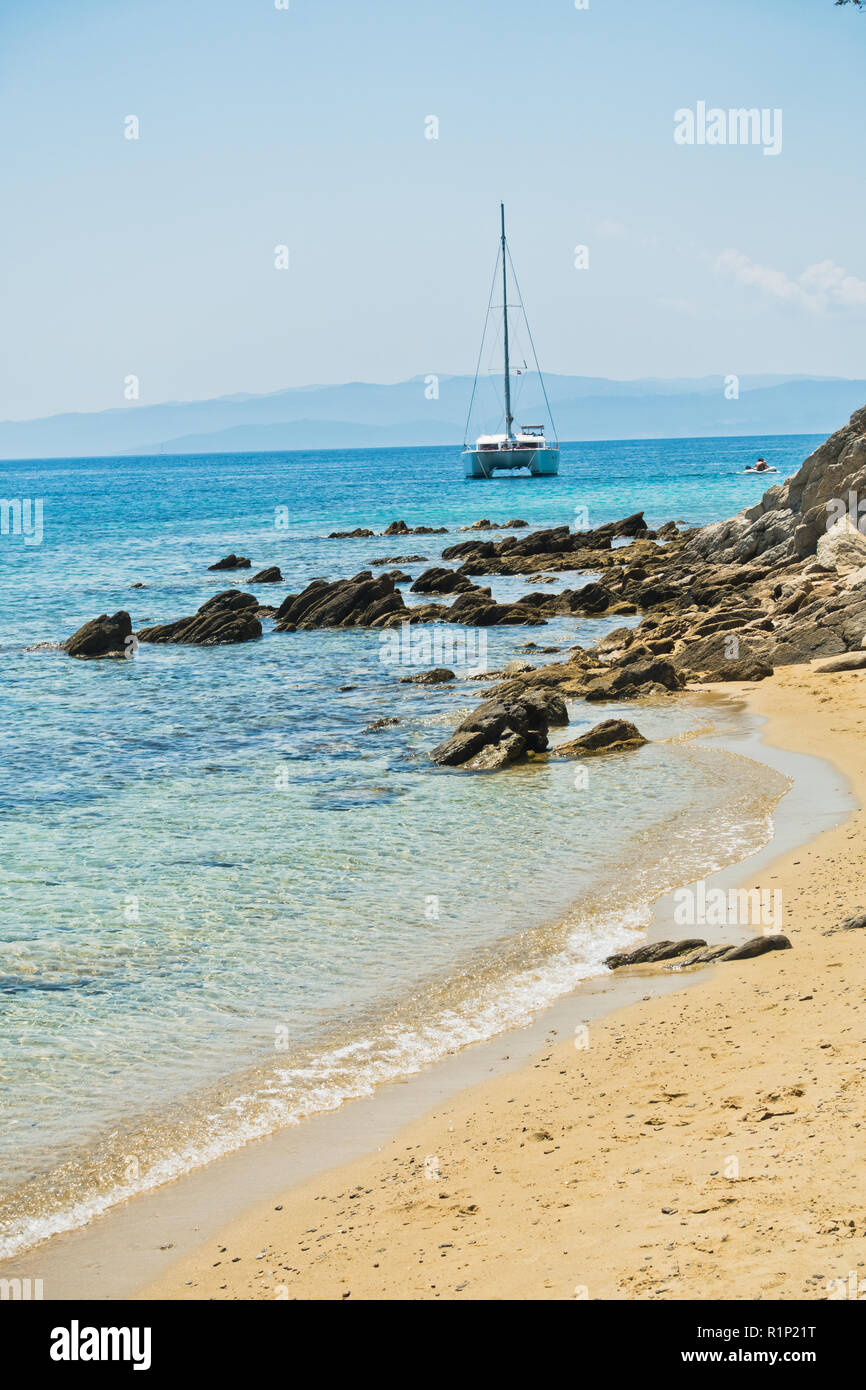 Felsen und Segelboote am Ende von Koukounaries Strand, Sommerurlaub auf der Insel Skiathos, Griechenland Stockfoto