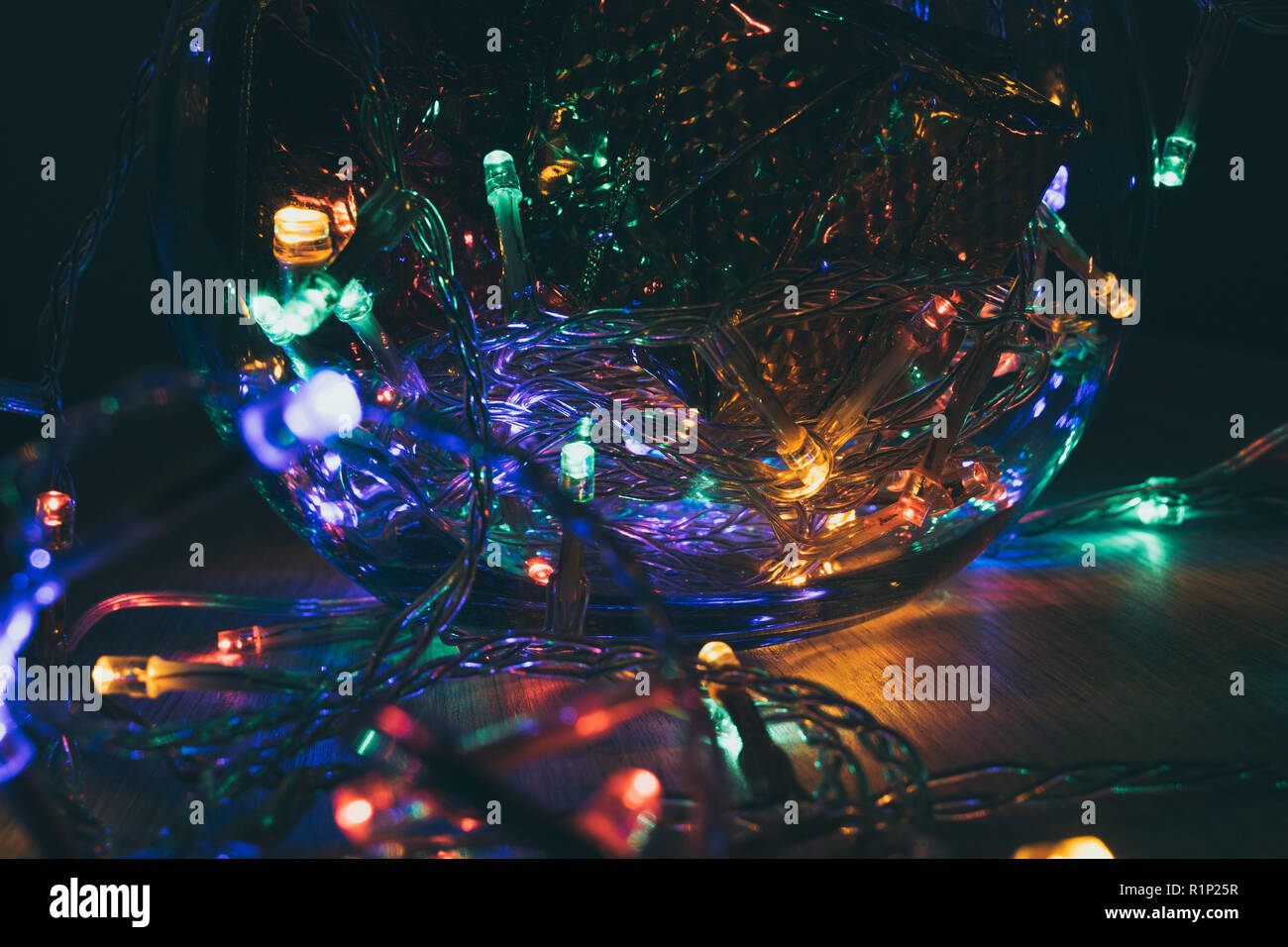 Weihnachtsbeleuchtung innen eine Kristallkugel auf einem hölzernen Hintergrund. Weihnachtsdekoration Stockfoto