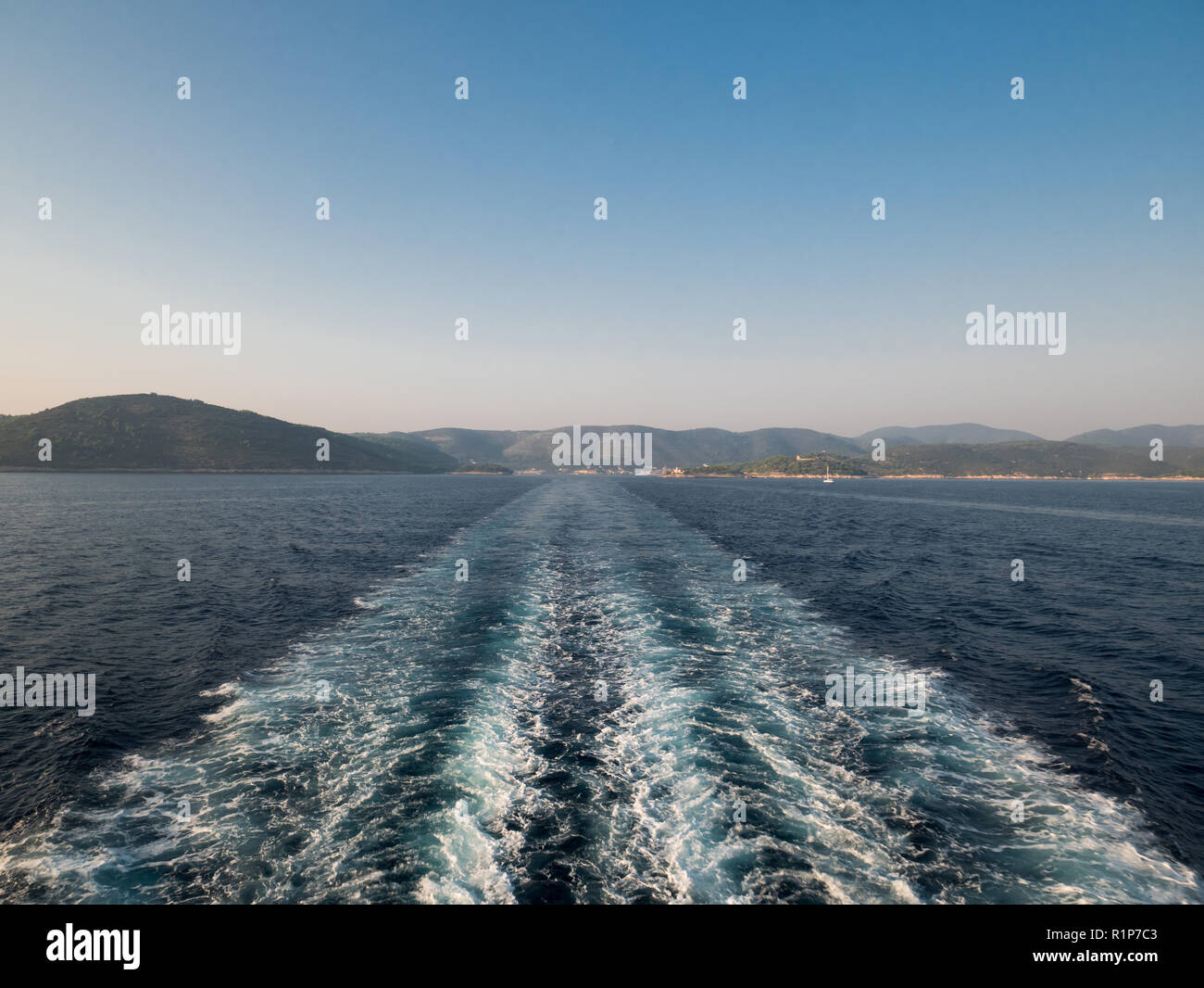 Kreuzfahrtschiff trail auf blaues Meer mit Insel Vis in Kroatien im Hintergrund Stockfoto