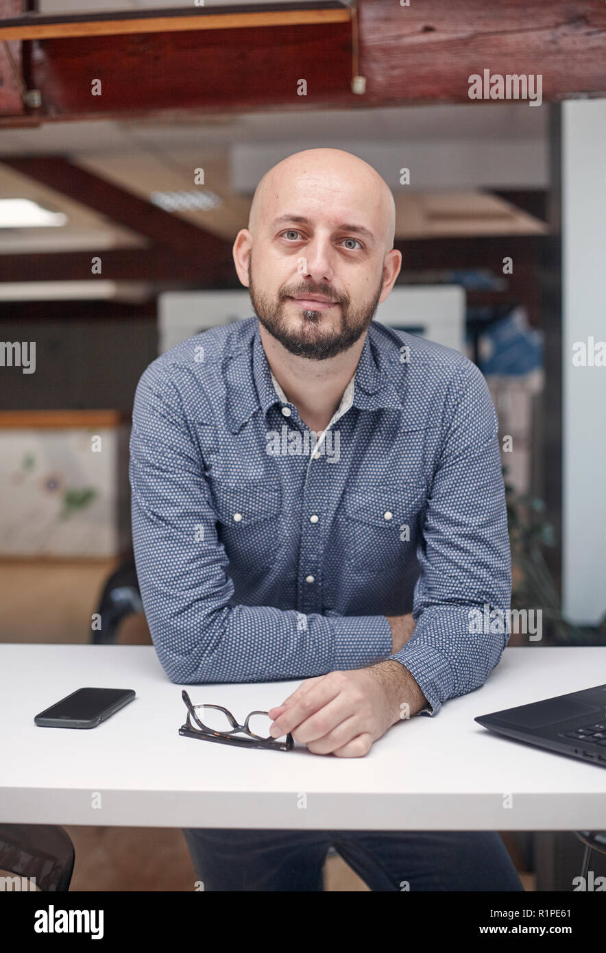 Ein junger Mann hoch, 30-39 Jahre, white-collar worker, lehnte sich vor, die Kamera schaut. obere Körper geschossen. Stockfoto