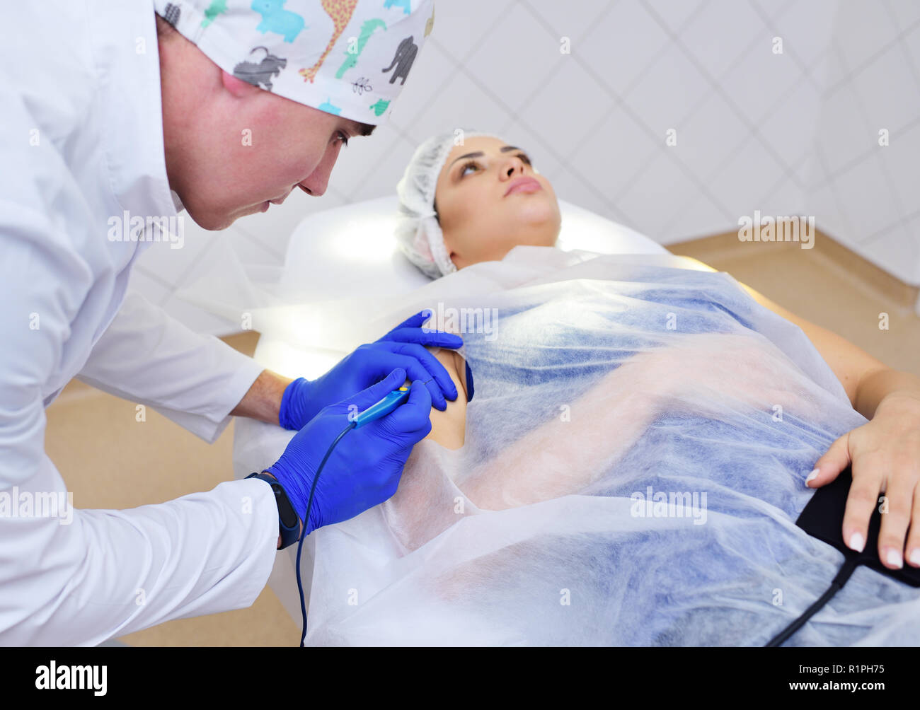 Der Chirurg Kosmetikerin entfernt Frau Muttermal des Patienten oder Muttermal auf der Hand mit einem Radio wave Messer. Hf Hochfrequenz- apparatu Stockfoto