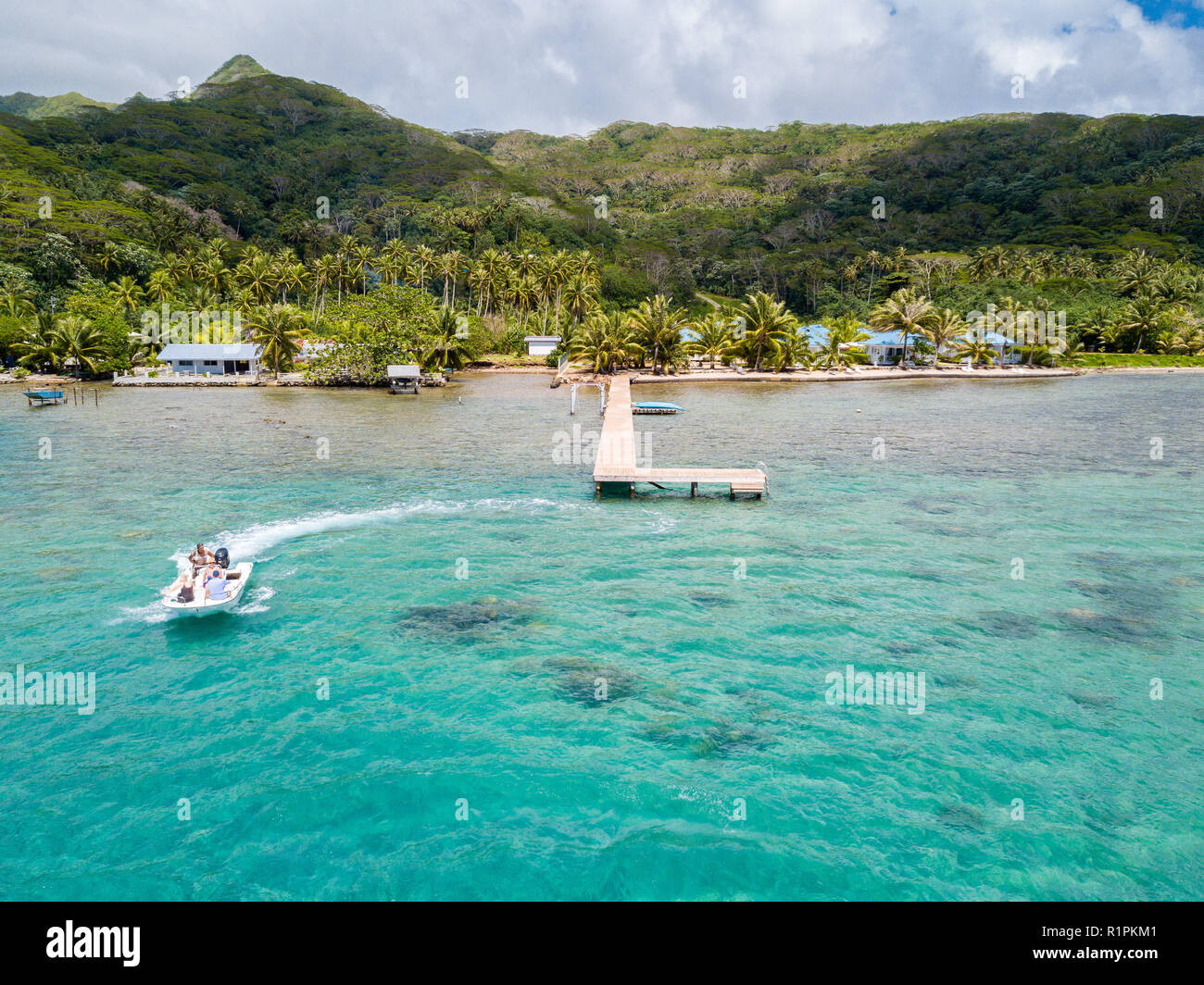 Touristen fahren mit hoher Geschwindigkeit Jet Boot in einer atemberaubenden Azurblauen türkisfarbenen Lagune, grüne Smaragd Insel zurück. Tahiti, Französisch-Polynesien, Ozeanien. Stockfoto